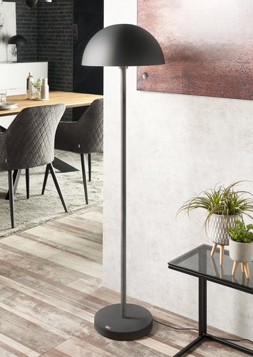 Schräg fotografierte Stehlampe aus matt dunkelgrauem Aluminium mit halbkugelförmigem Schirm und schlankem Fuß