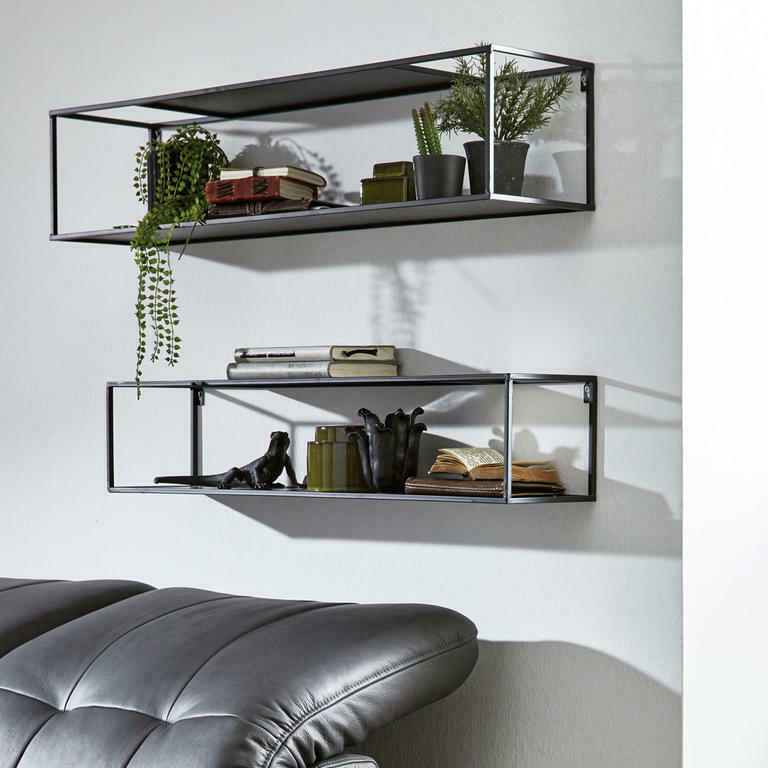Wohnbeispiel mit dekoriertem zweiteiligem Wandregal Zwei schwarze Wandregale im Wohnzimmer dekoriert, jeweils mit Büchern Pflanzen und Bildern bestückt