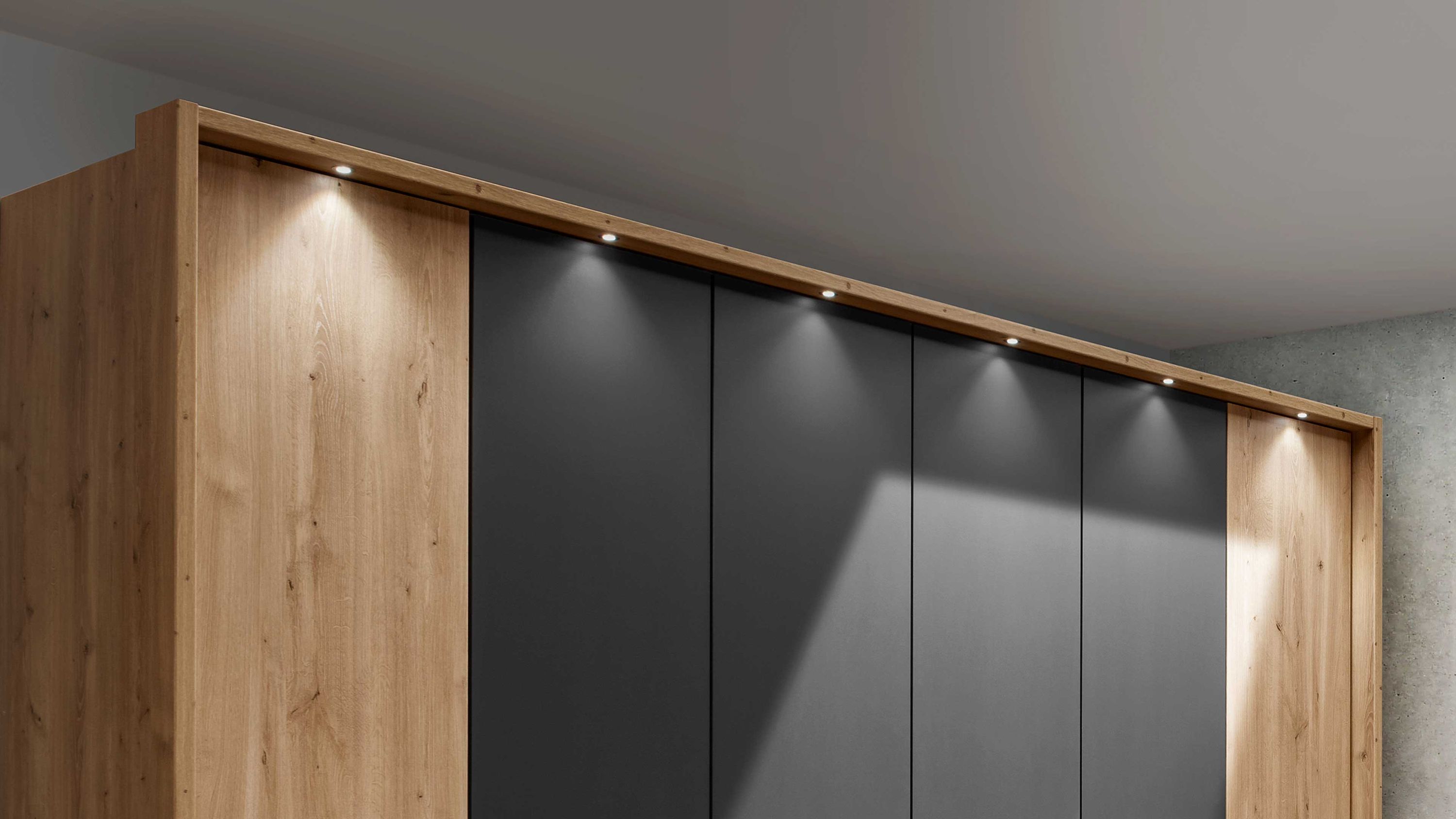 Kleiderschrank mit Holzoptik und dunklen Türen Großer Kleiderschrank mit sechs Türen in Holzoptik und dunklen Fronten mit integrierter Beleuchtung