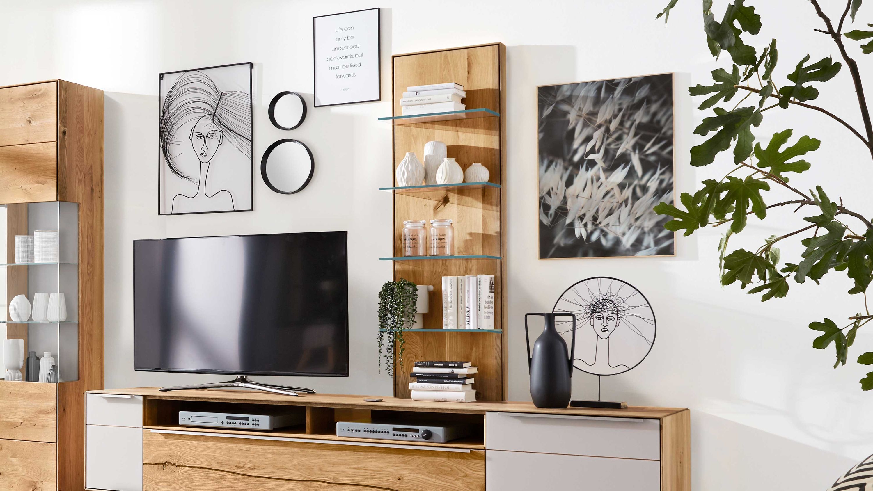Aufsatzpaneel mit Glasregalen in Holzoptik Aufsatzpaneel aus Holz mit vier Glasregalen in einem Wohnzimmer mit Fernseher und Dekoration