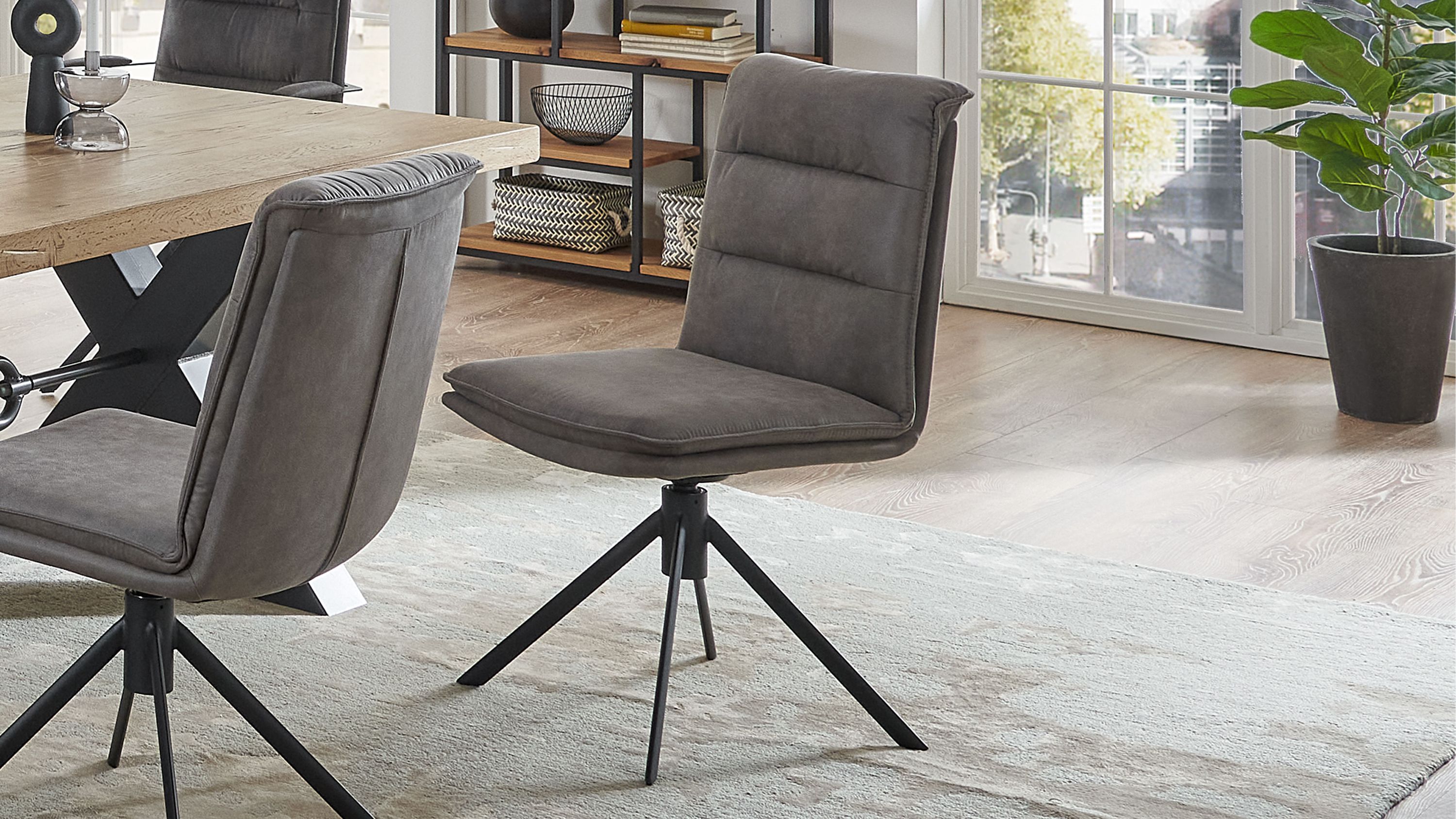 Grauer Polsterstuhl mit schwarzem Metallgestell Grauer Polsterstuhl mit gepolsterter Rückenlehne und schwarzem Metallgestell mit vier Beinen