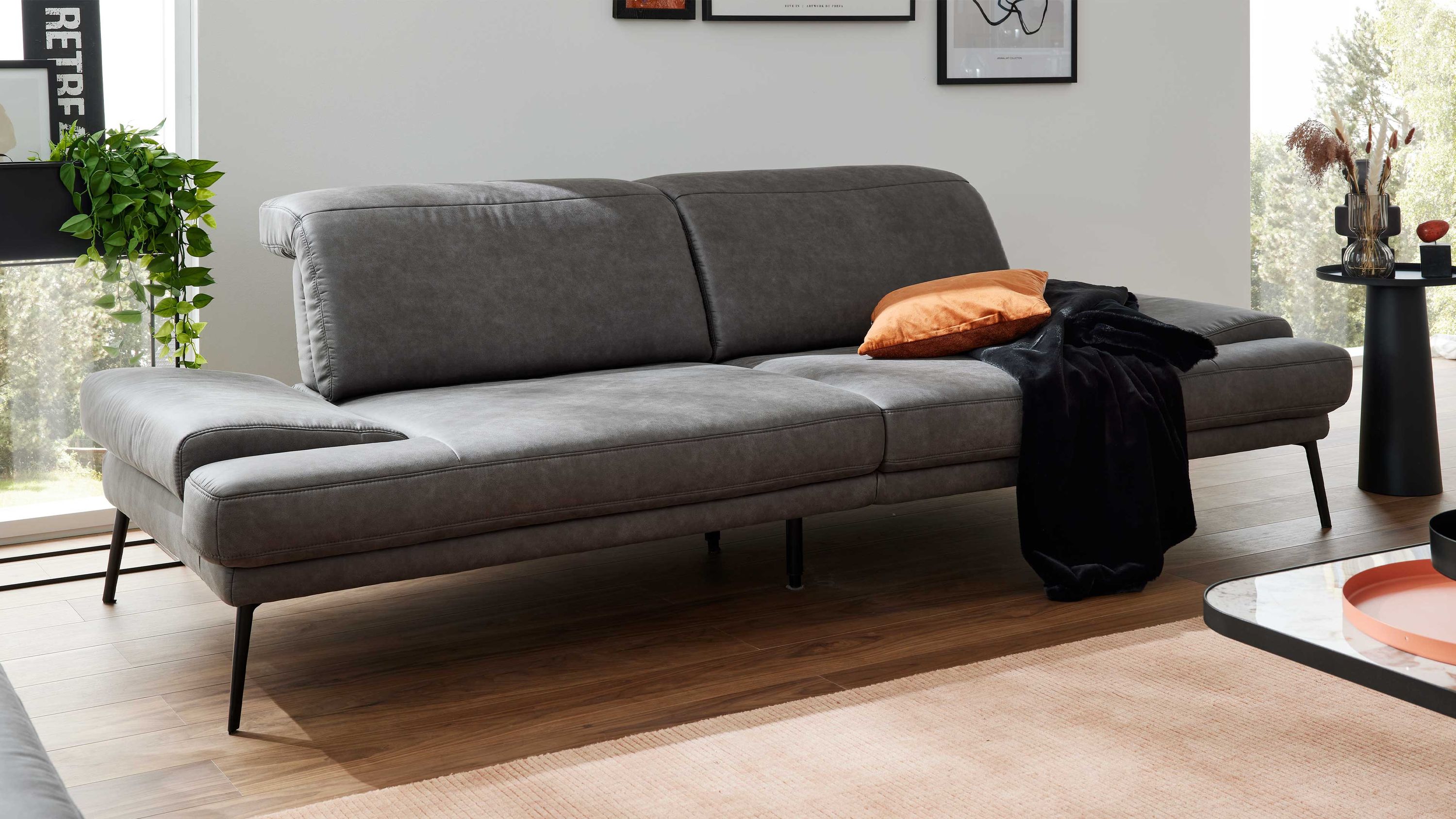 Graues Sofa mit zwei Sitzflächen verstellbaren Rückenlehnen und schwarzen Metallfüßen in modernem Wohnzimmer