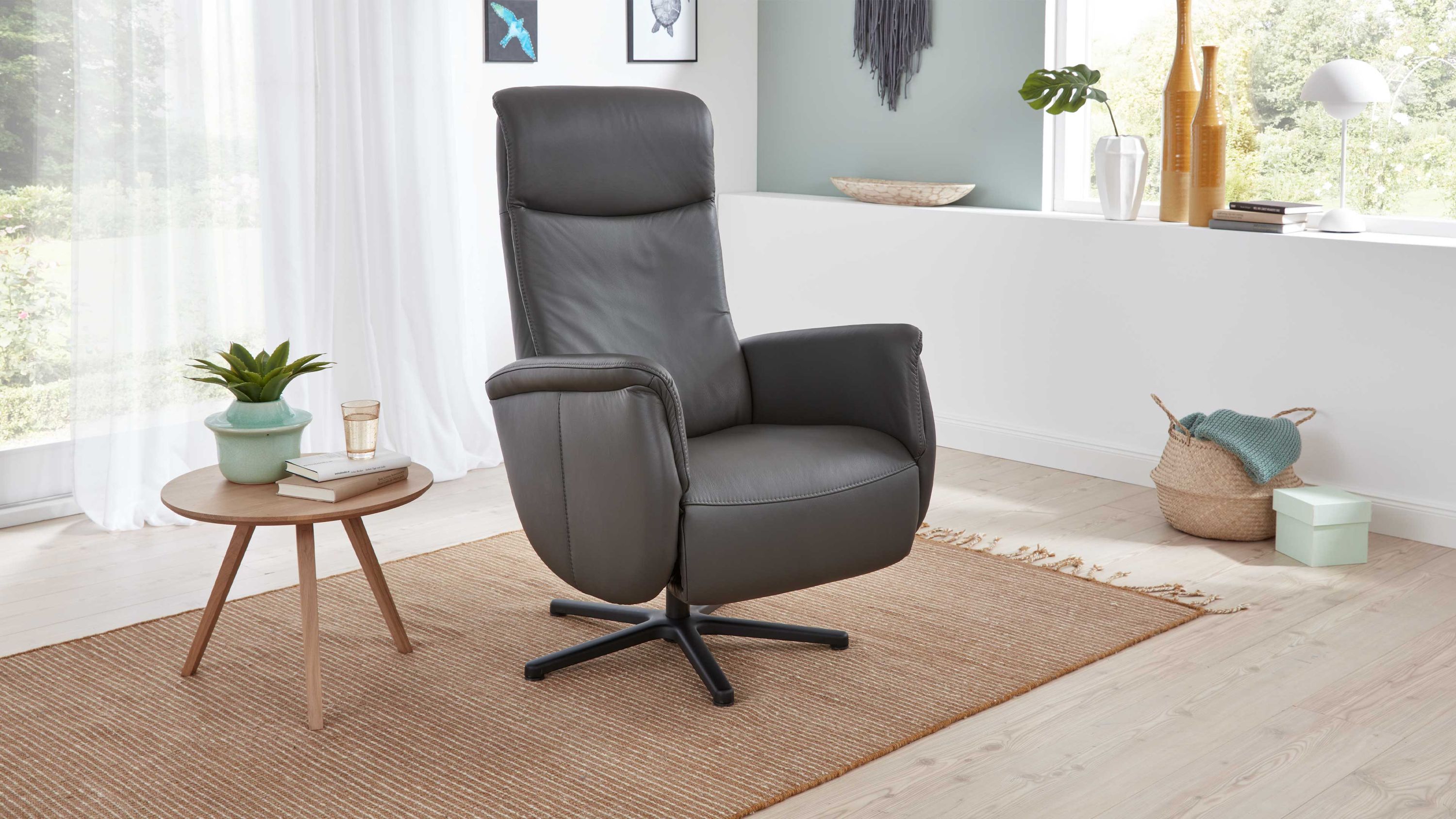 Relaxsessel anthrazit mit Sternfuß Anthrazitfarbener Relaxsessel mit hoher Rückenlehne und schwarzem Sternfuß in modernem Wohnzimmer