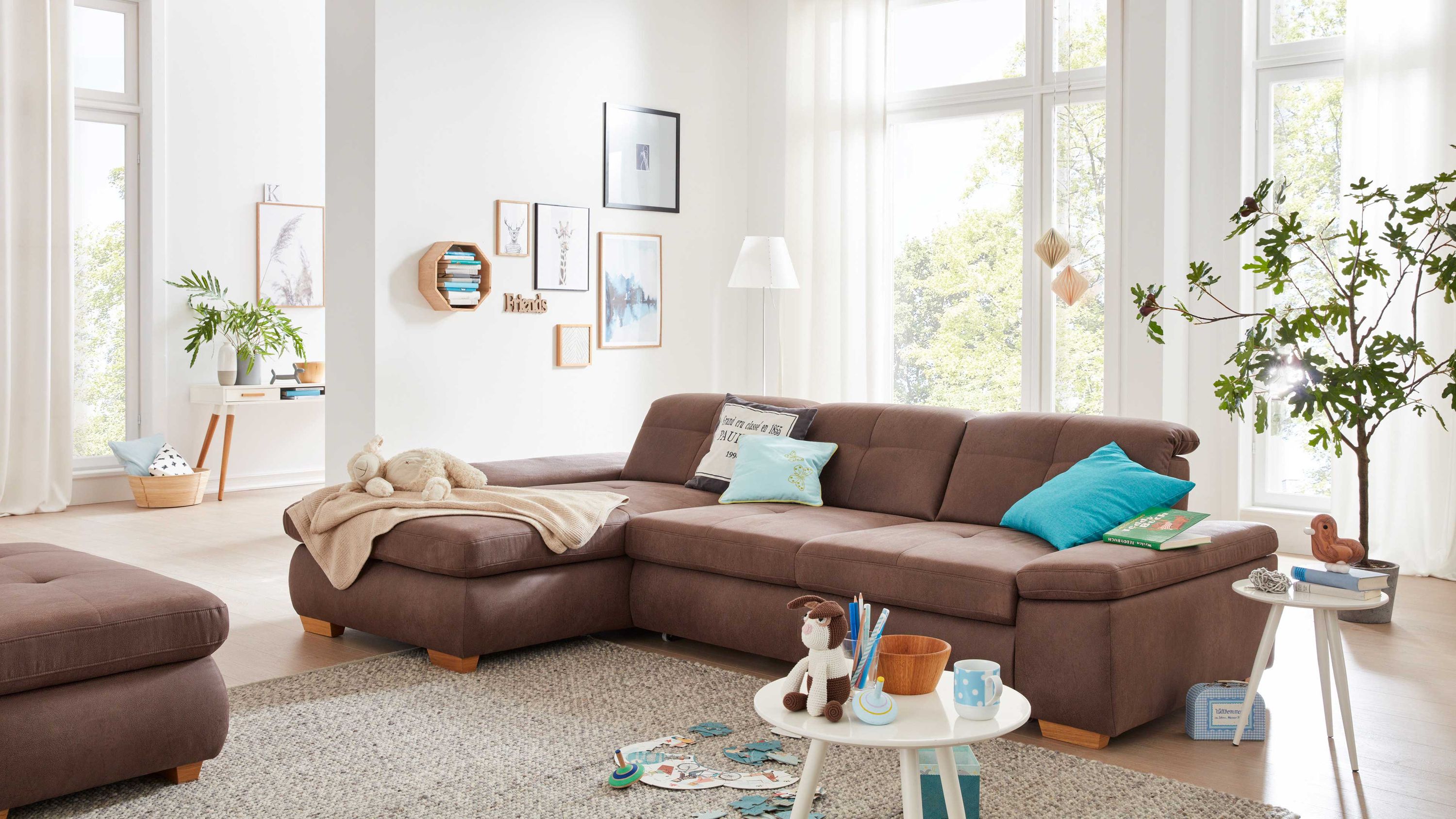 Ecksofa mit nougatfarbener Mikrofaser Holzfüße mit Kissen und Decke in hellem Wohnzimmer