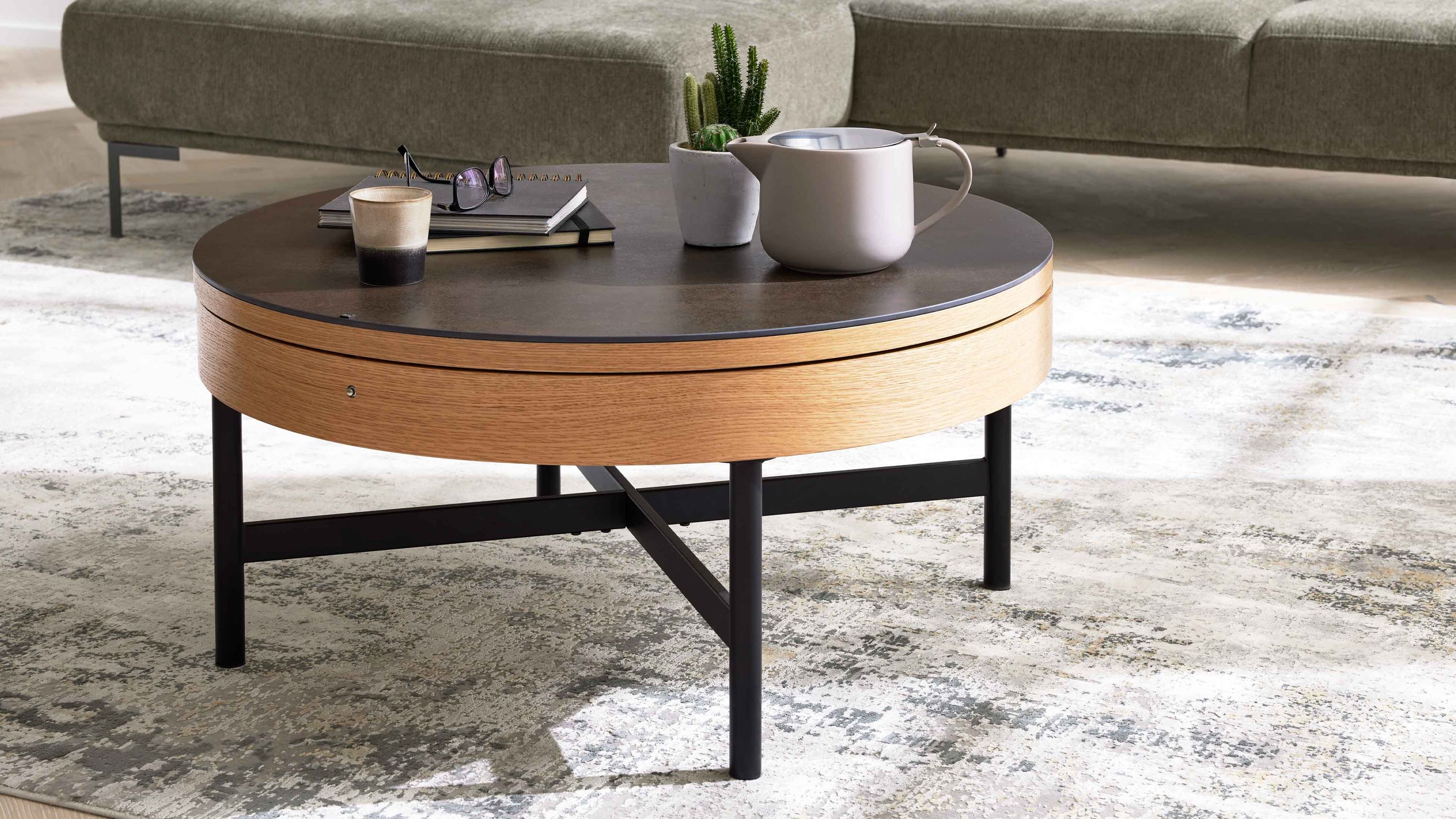 Runder Couchtisch mit Holzrand und schwarzem Metallgestell Runder Couchtisch mit dunkler Tischplatte hellem Holzrand und schwarzem Gestell aus Metall