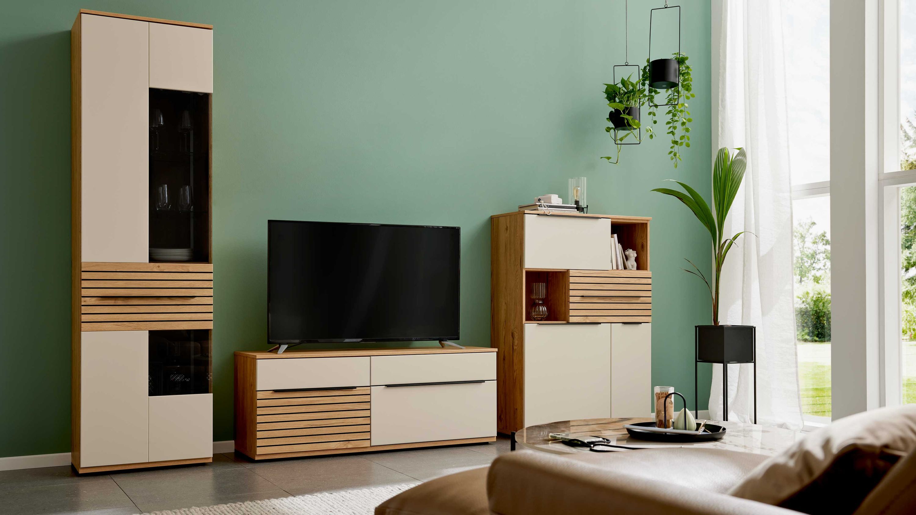Wohnwand in Sandbeige und Risseiche mit Schränken und TV-Board Wohnwand mit hohen und niedrigen Schränken in sandbeige und risseiche mit Glastüren und Schubladen