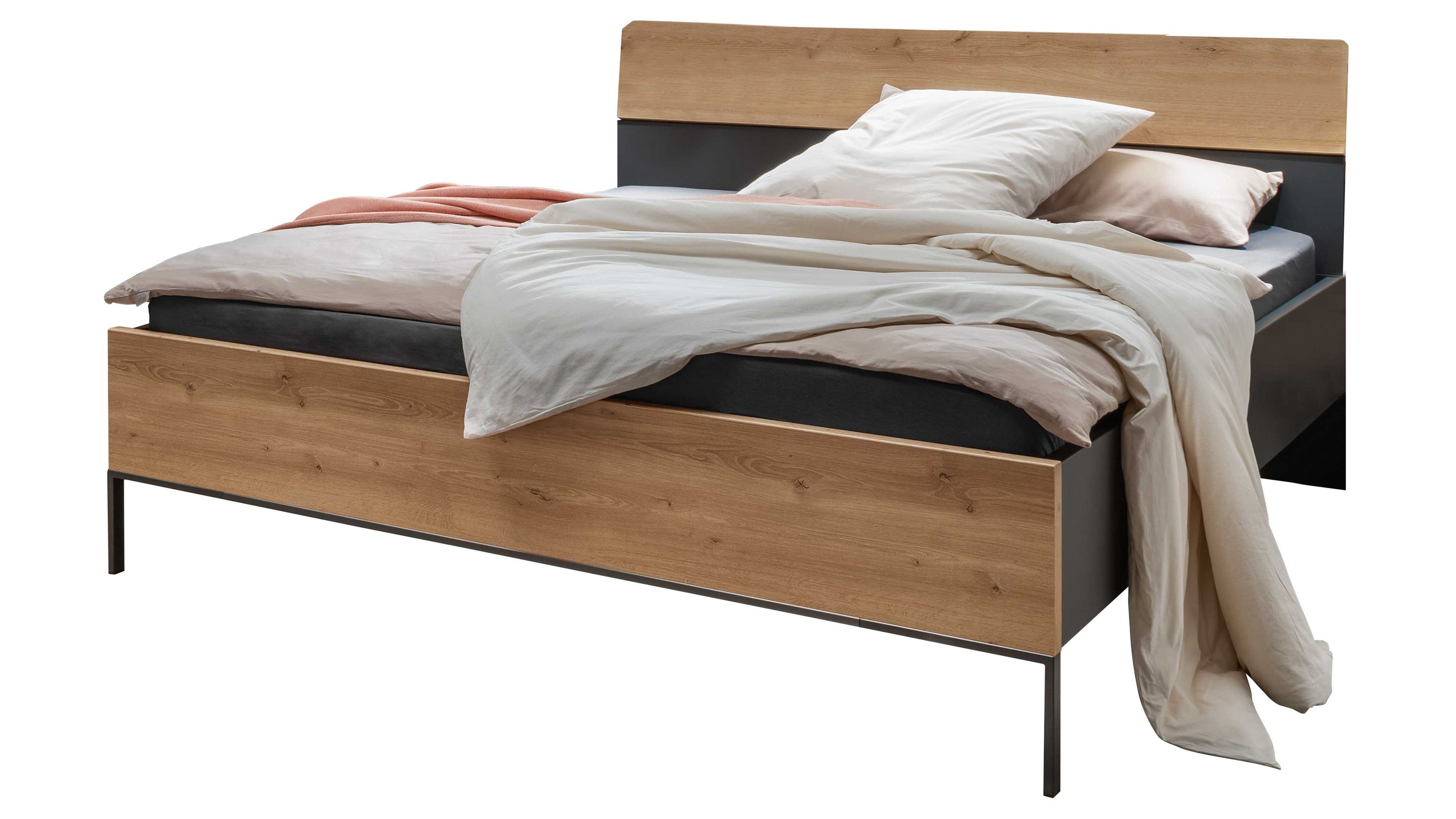 Bettgestell mit Holzoptik und dunklem Rahmen Bettgestell mit Kopf- und Fußteil in Holzoptik und dunklem Rahmen mit hellen Bettwaren