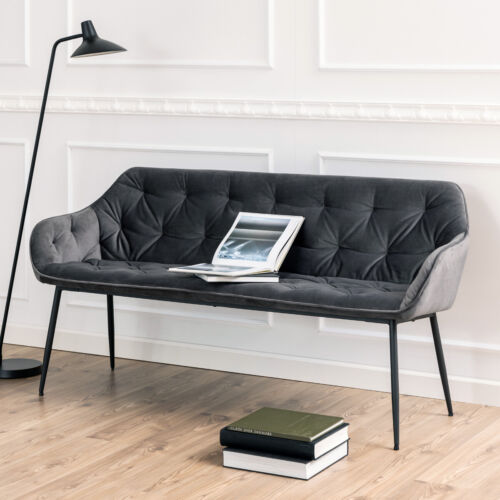 Graue Sofabank mit Rautenheftung und Beinen in modernem Wohnraum mit Stehlampe  Büchern und Tablet