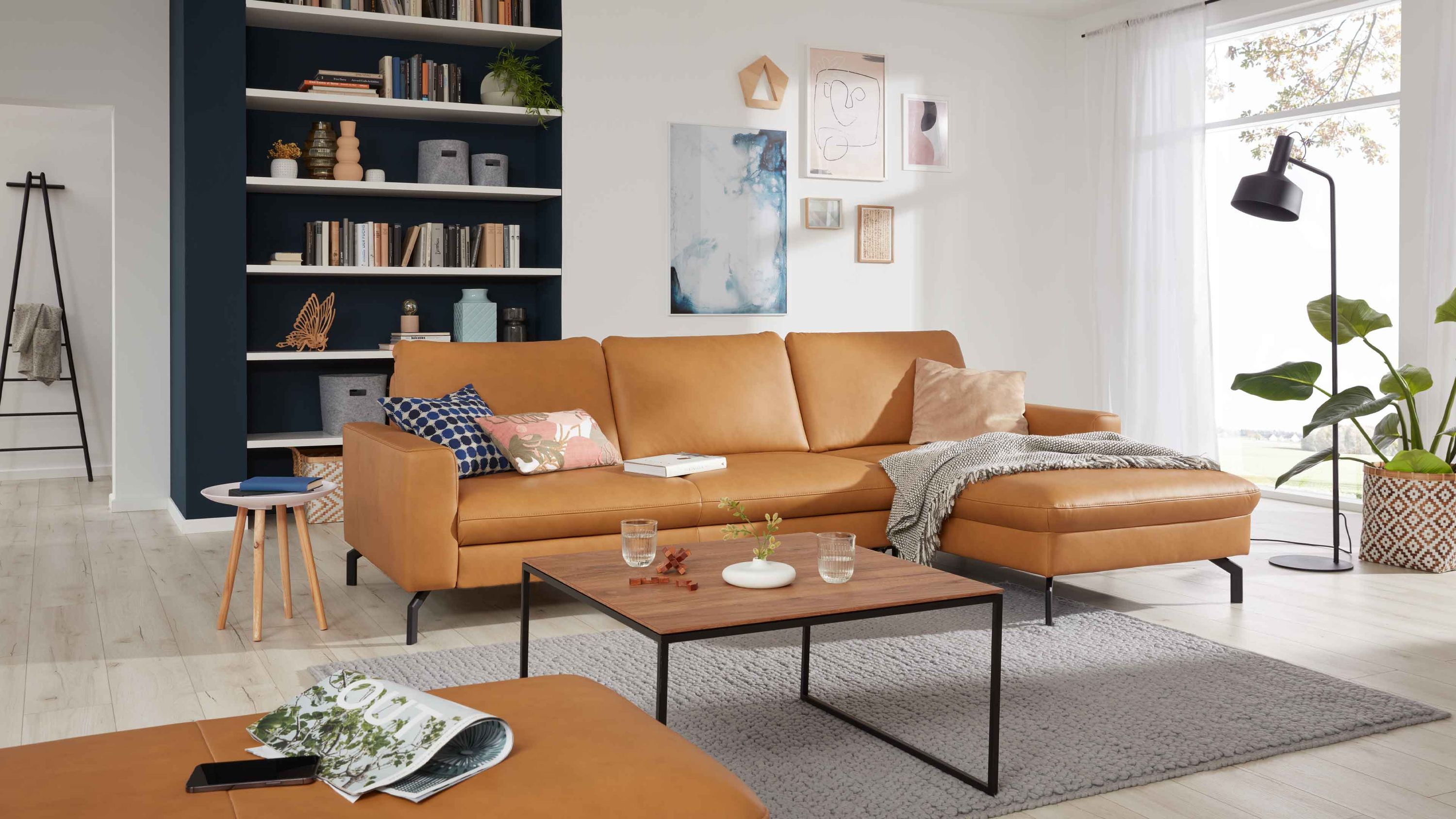 Ecksofa mit kurkumafarbenem Lederbezug und schwarzen Metallfüßen in modernem Wohnzimmer