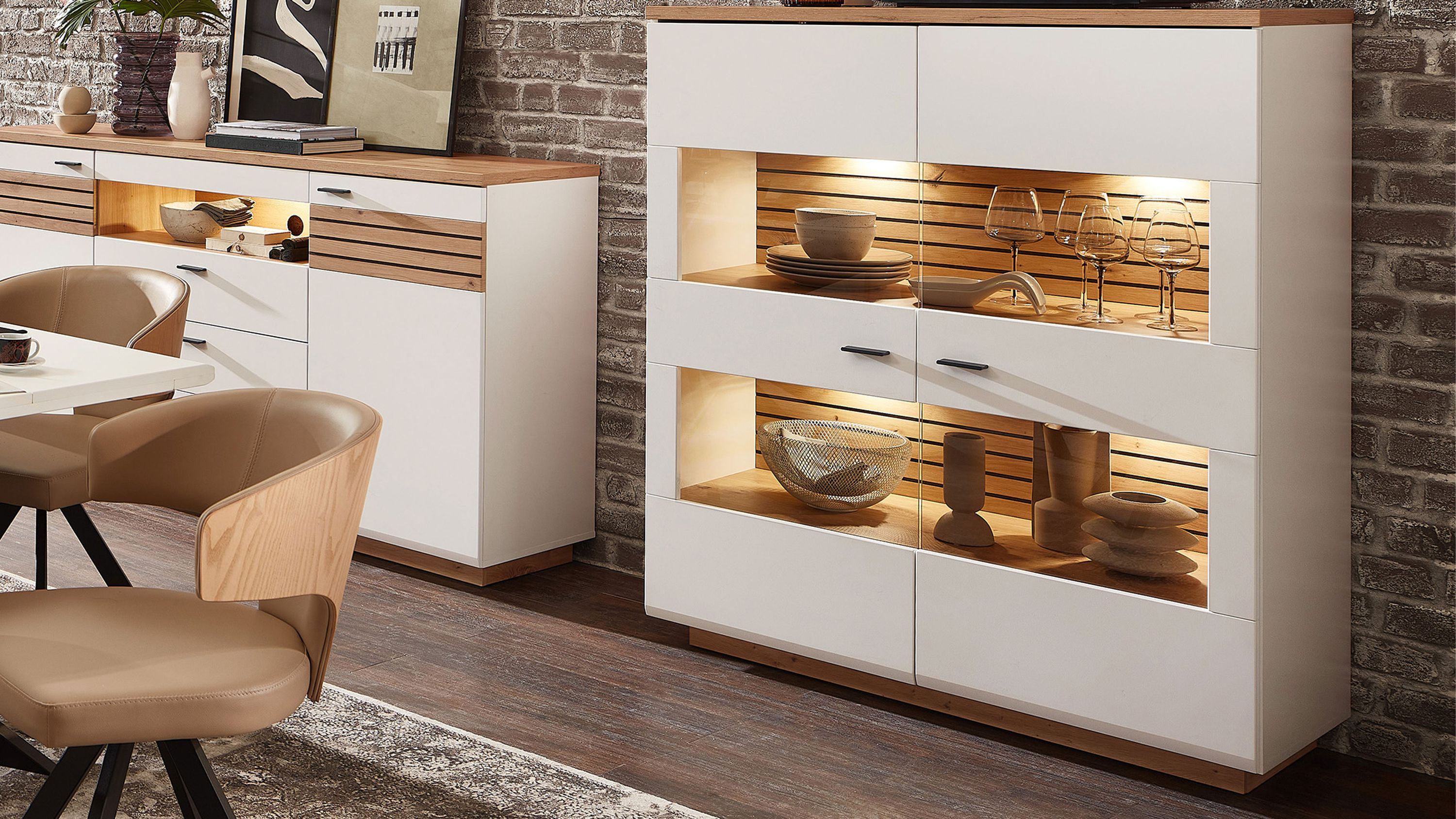Weißes Highboard mit zwei Türen und beleuchteten Glasfächern Holzdetails in Eichefarben