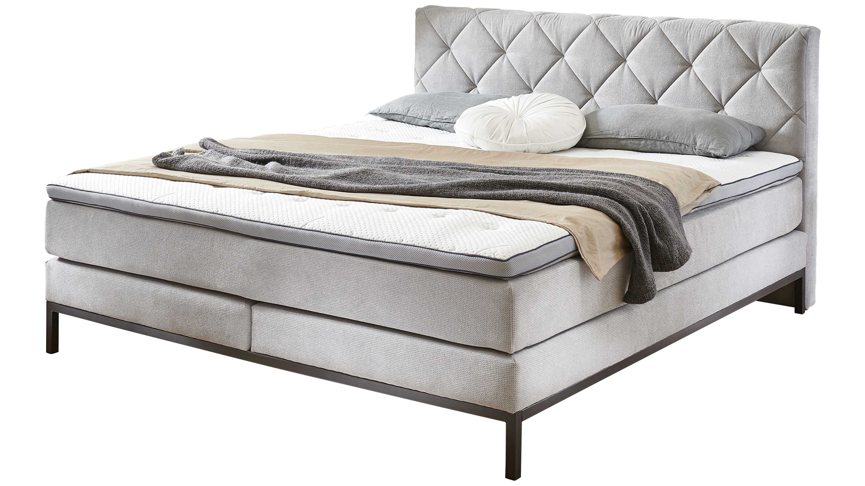 Boxspringbett mit silbergrauem Stoffbezug und gepolstertem Kopfteil Boxspringbett mit silbergrauem Stoffbezug gepolstertem Kopfteil mit Steppmuster und Metallgestell