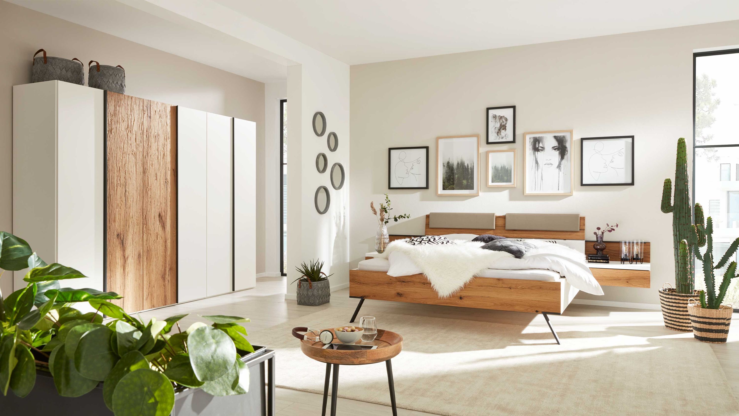 Schlafzimmer mit weißem Kleiderschrank und Doppelbett mit Holzrahmen Schlafzimmer mit weißem Kleiderschrank und Holzelementen Doppelbett mit Holzrahmen und weißen Bettdecken