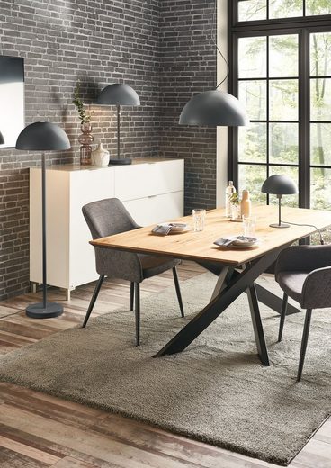 Zeitgemäßer Essbereich mit Pendelleuchte Große schwarze Pendelleuchte über gedecktem Holztisch im modernen Essbereich, aus frontaler Perspektive fotografiert