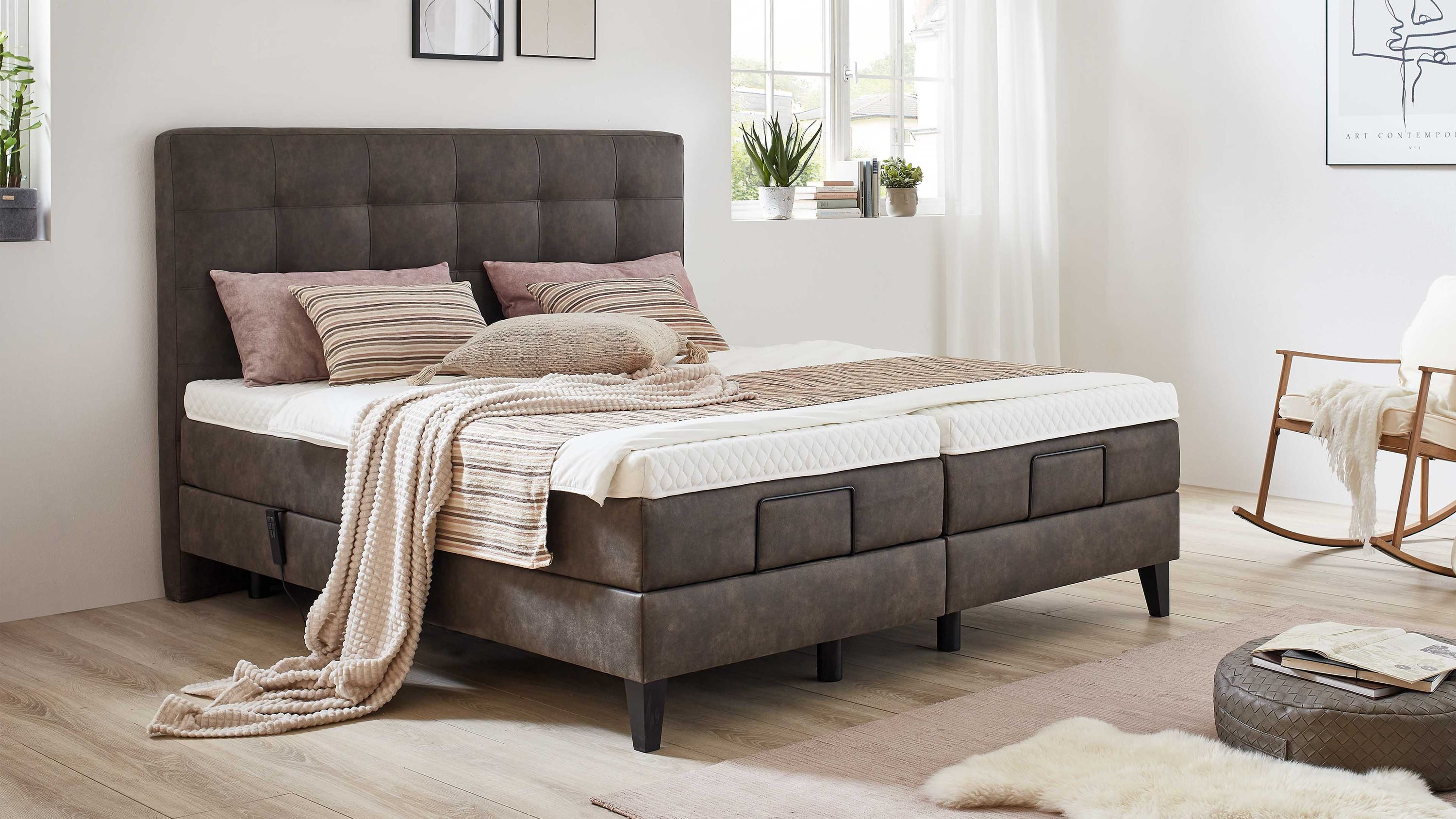 Boxspringbett mit gepolstertem Kopfteil in schlammfarbener Farbe Boxspringbett mit gepolstertem Kopfteil in schlammfarbener Stoffoptik mit Kissen und Decke in neutralen Farben