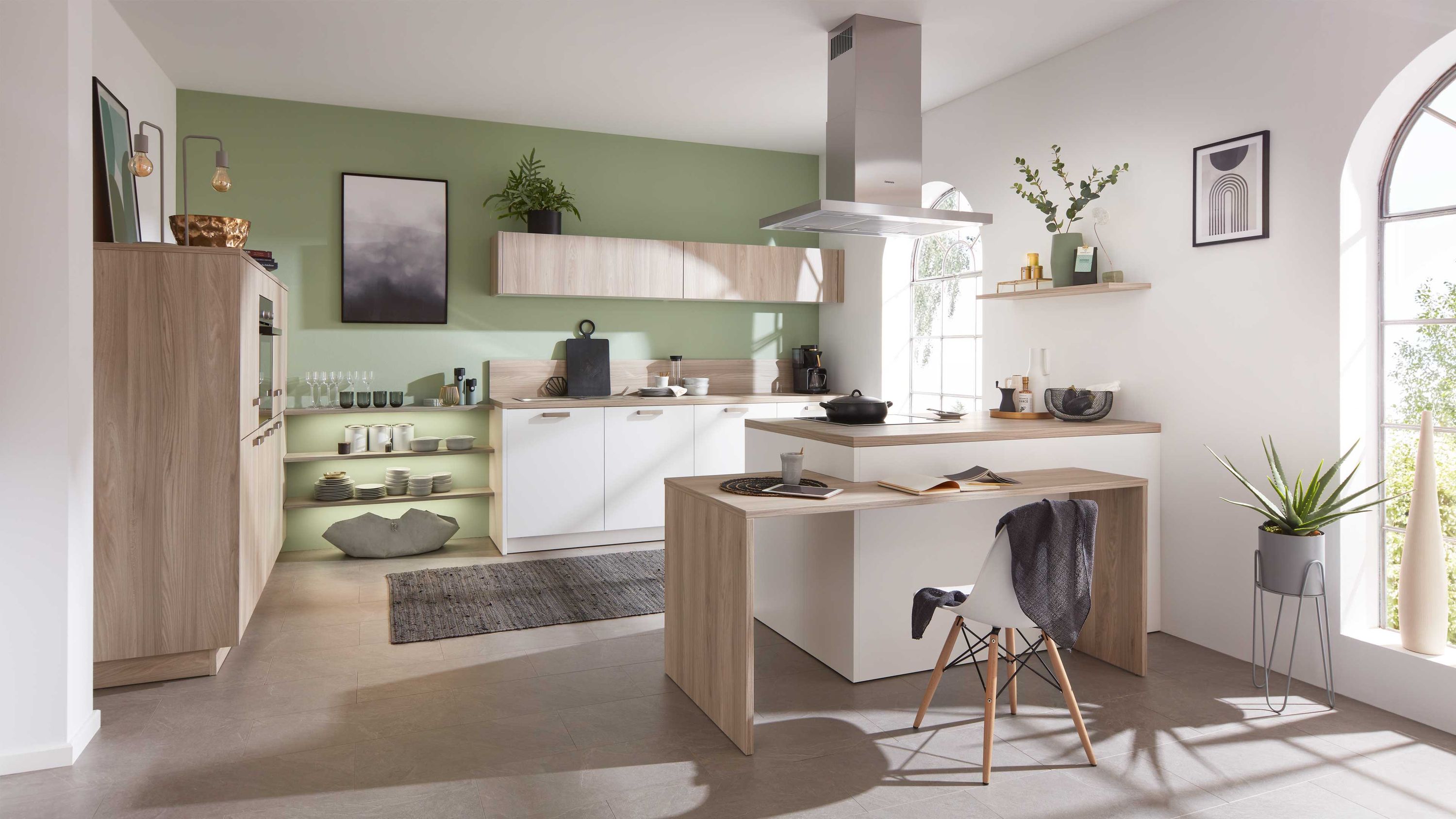 Stilvolle Küche mit Holzakzenten grüner Wandfarbe und natürlichem Lichteinfall Weiße und Holzfront-Küche mit Insel grünen Wänden offenen Regalen Edelstahlgeräten Fensterlicht Pflanzen
