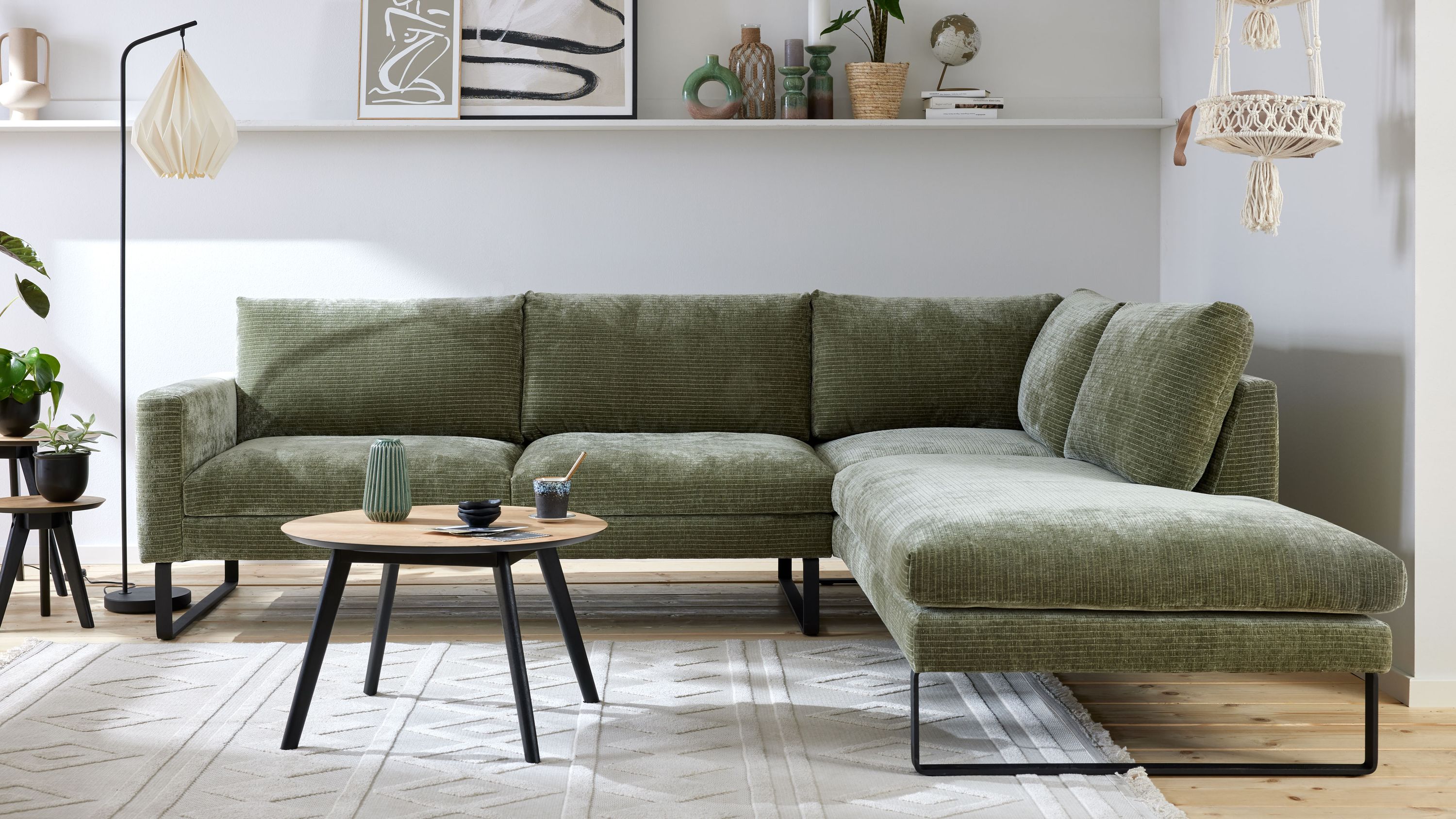 Ecksofa mit schildkrötenfarbenem Bezug und schwarzen Kufenfüßen Ecksofa mit schildkrötenfarbenem Bezug und schwarzen Kufenfüßen in modernem Wohnzimmer