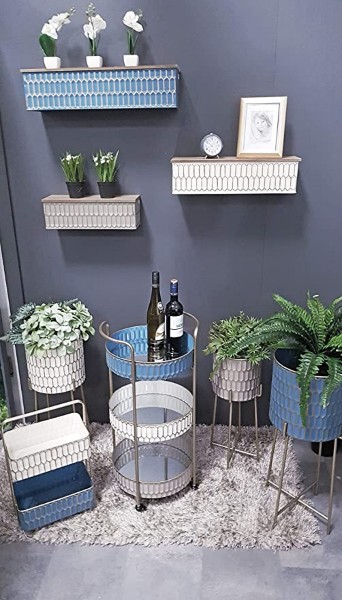 Drei bepflanzte Blumensäulen in Creme Taupe Petrol in modernem Raum mit grauer Wand Hängeregalen Teppich arrangiert