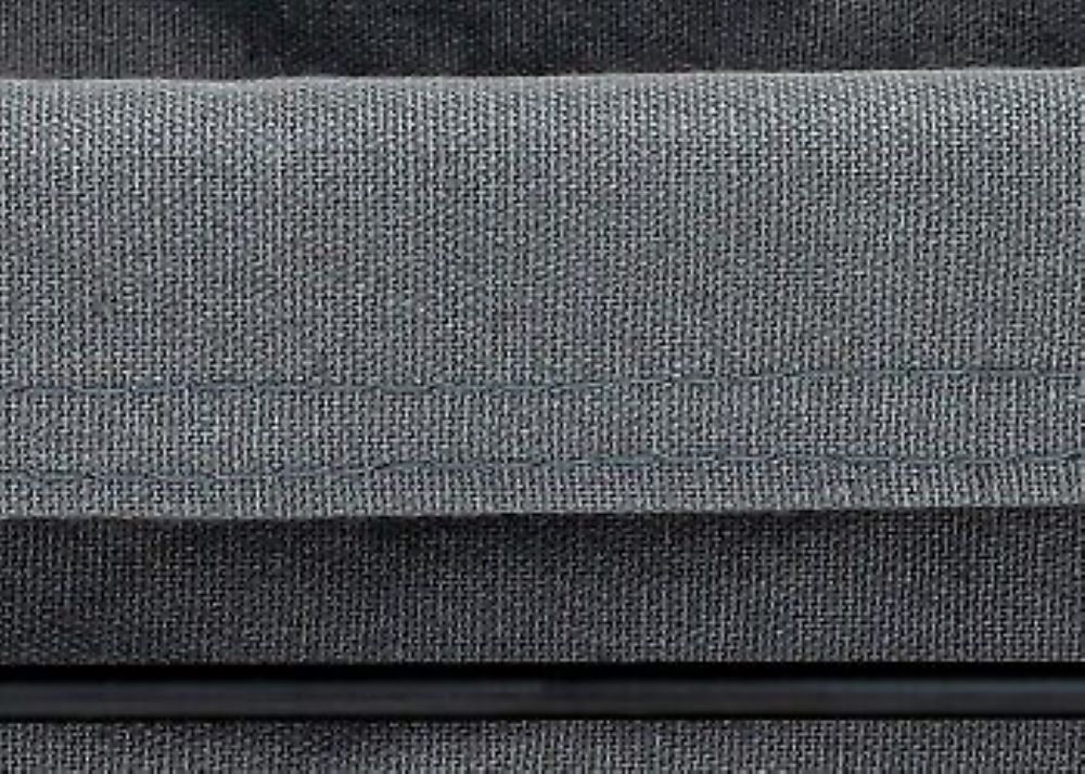 Stoffdetail in Anthrazit  Fokus auf Textilstruktur und Rahmenkante, moderne Materialkombination