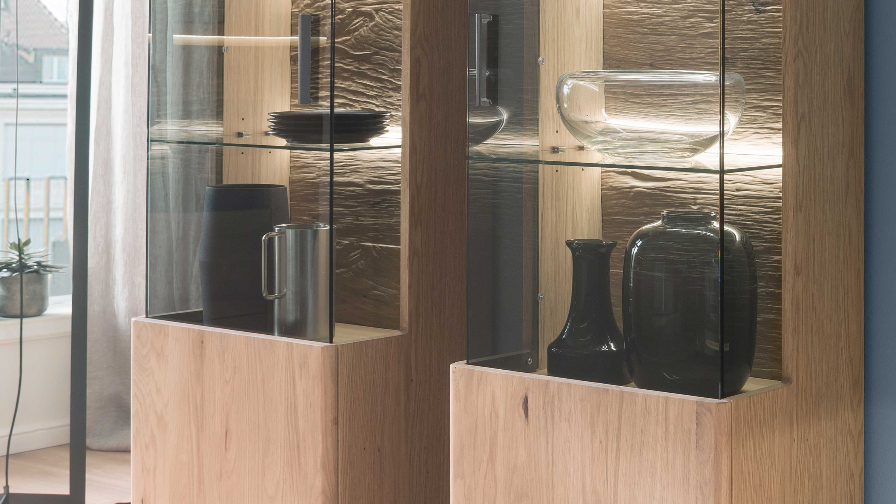 Zweiteiliges LED-Beleuchtungs-Set mit Holzrahmen und Glasfront in einem Wohnzimmerschrank