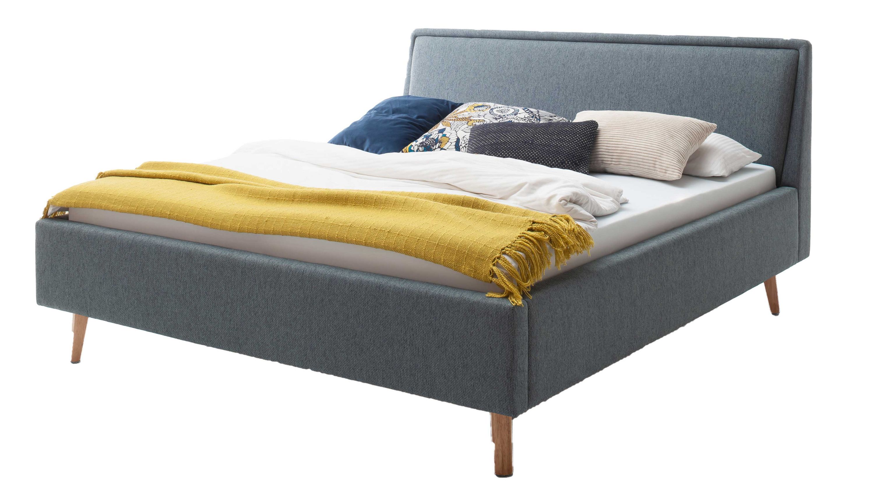 Polsterbett mit oceanfarbenem Bezug und Holzfüßen Polsterbett mit rechteckigem Kopfteil oceanfarbener Bezug und eichefarbene Holzfüße mit Bettdecke und Kissen belegt