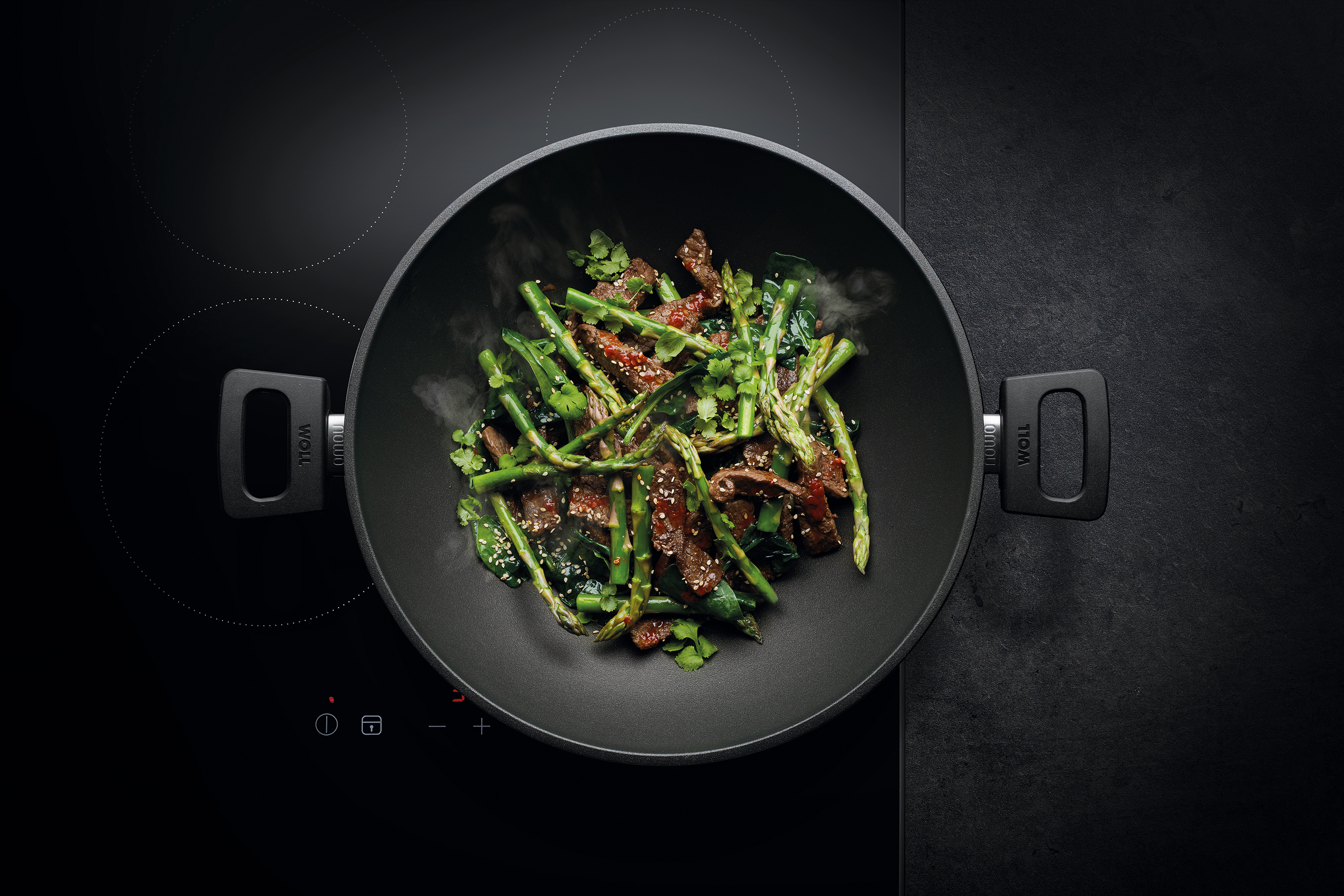 WOLL Wok mit Gemüse und Fleisch auf einem Induktionskochfeld.