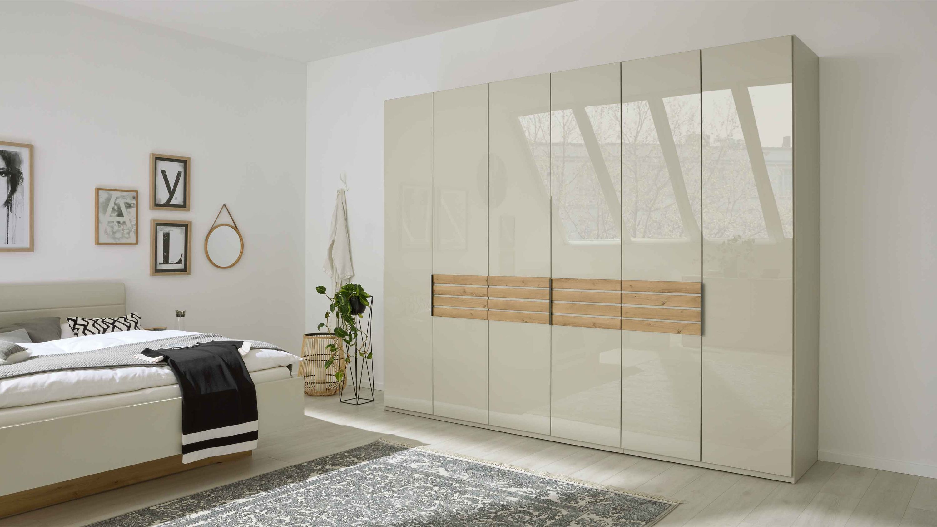 Kleiderschrank mit sechs Türen champagnerfarbenen Fronten und mittigen Holzleisten in Eicheoptik im Schlafzimmer