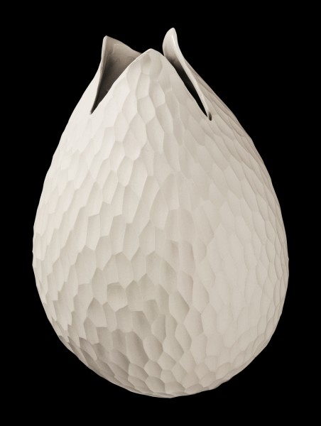 Beige Vase mit strukturierter Oberfläche  organisch gerundet mit spitz zulaufender Öffnung  vor schwarzem Hintergrund