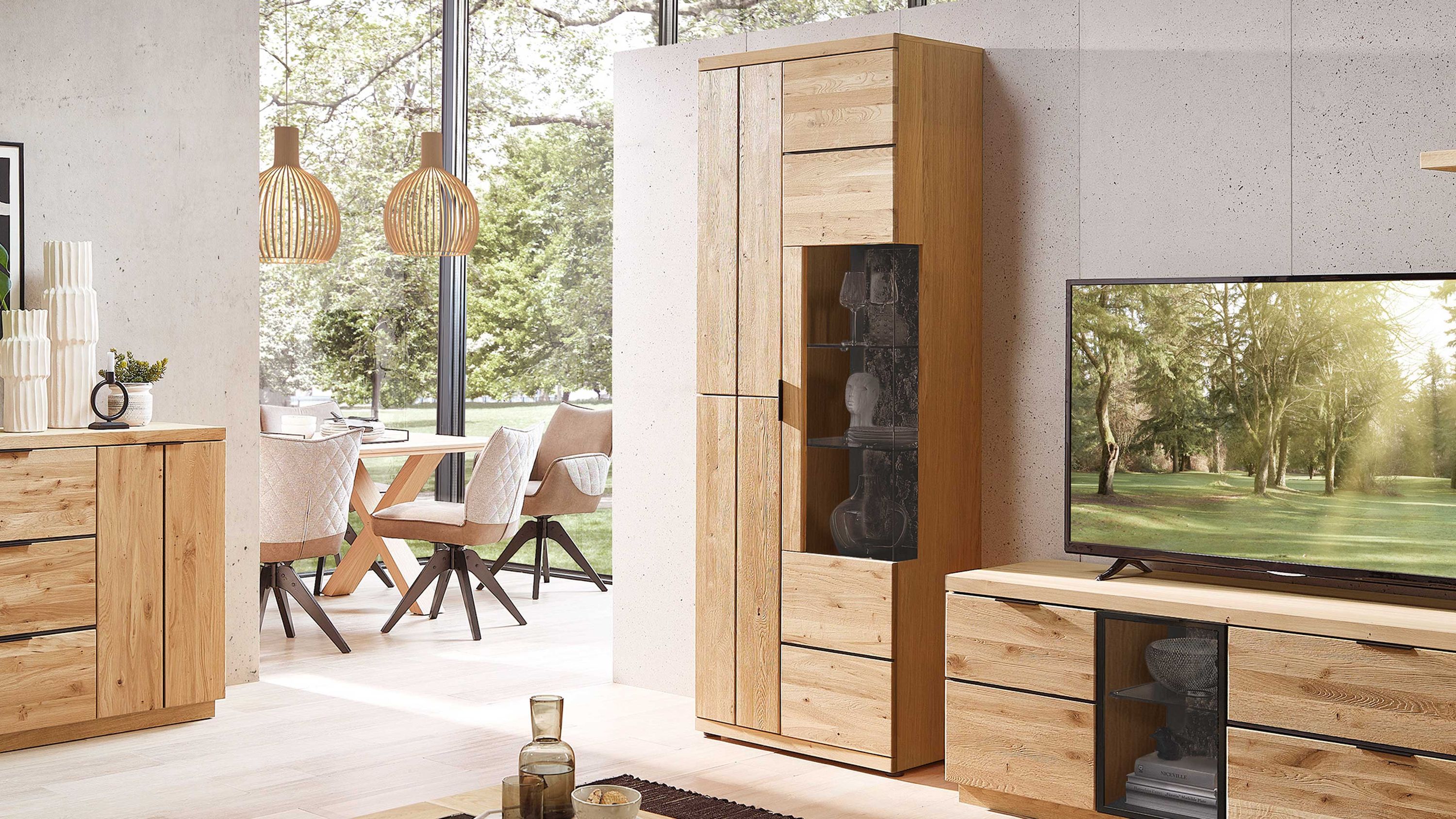 Vitrine mit drei Türen in Holzoptik Hohe Vitrine mit drei Türen und Glaseinsatz in hellbrauner Holzoptik in einem modernen Wohnzimmer