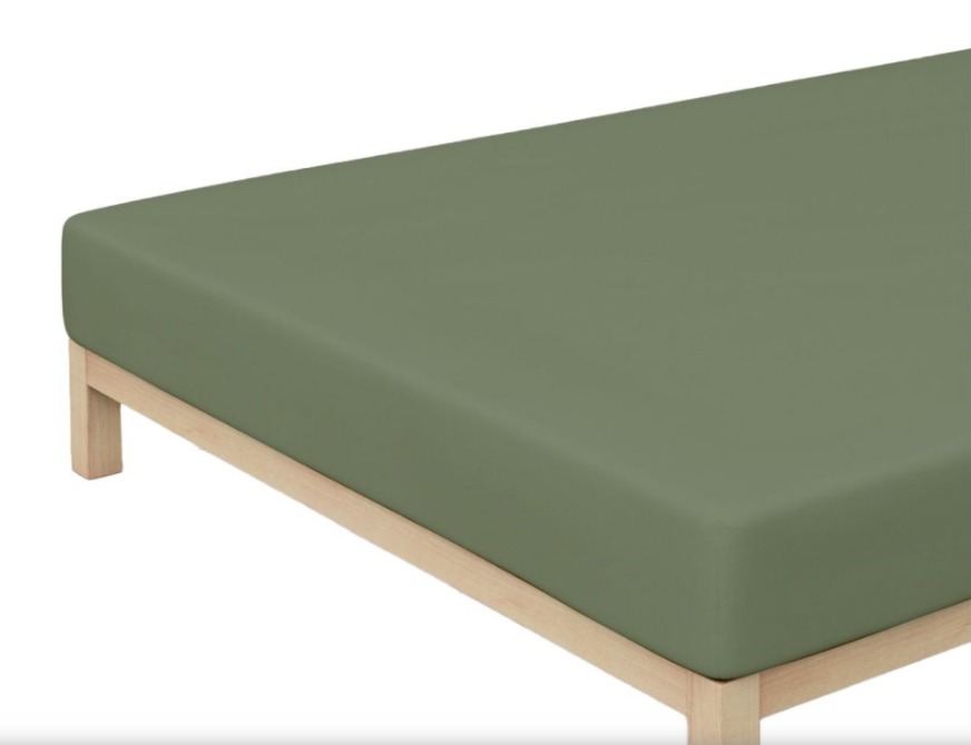 Ecke eines grünen Jersey-Spannbettlakens aus Baumwolle schräg von oben auf Matratze mit Holzrahmen fotografiert