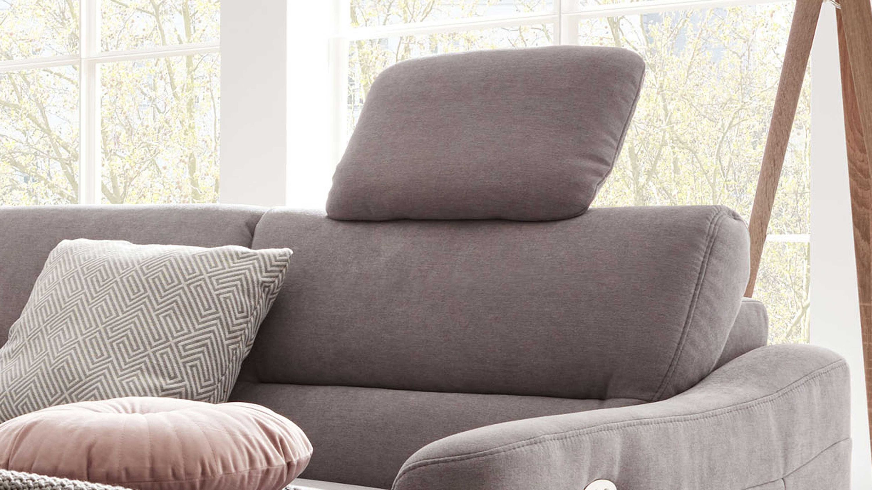 Sofa mit verstellbarer Kopfstütze und zwei Kissen in hellgrauer Stoffbezug