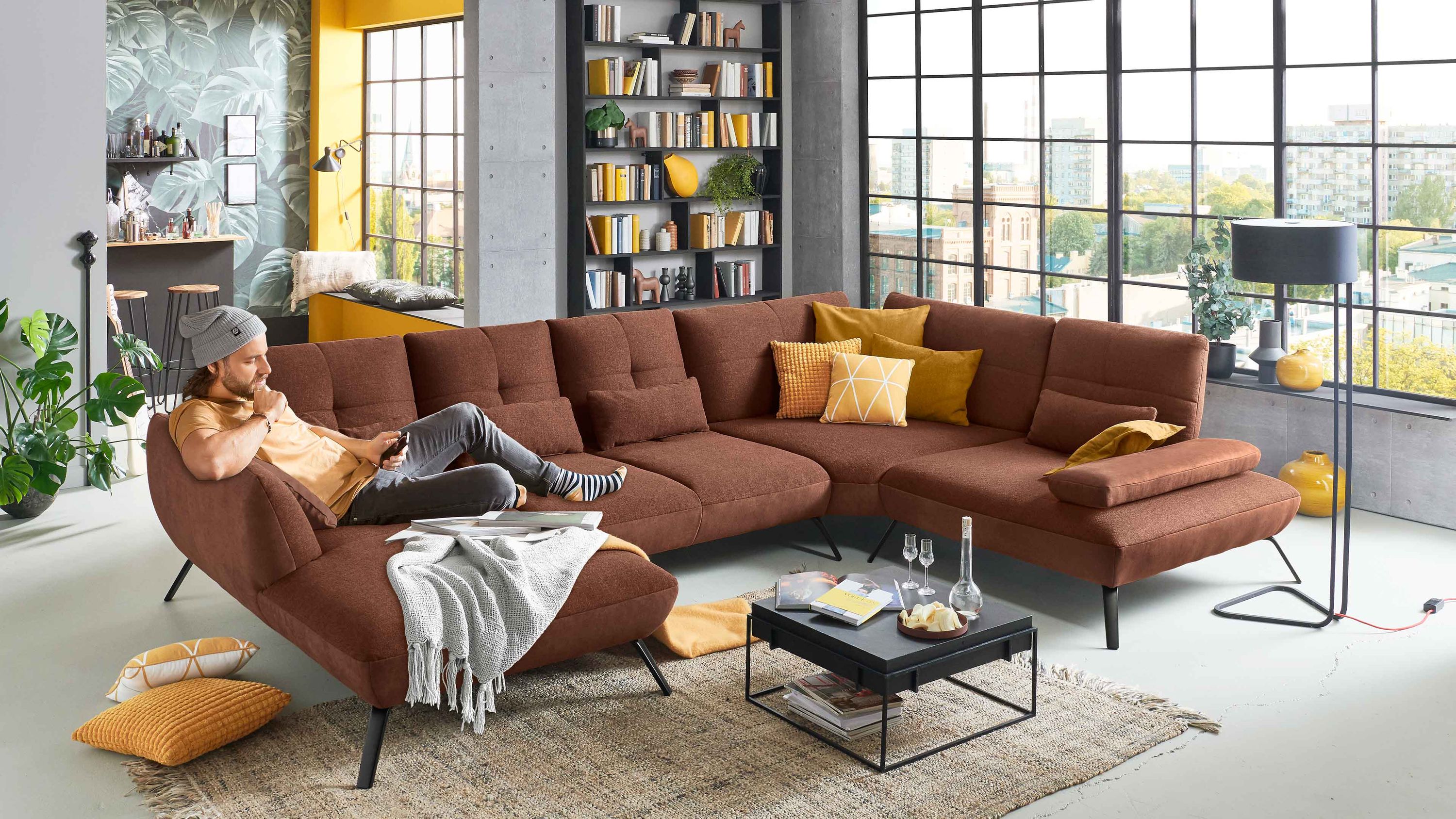 Wohnlandschaft mit kupferfarbenem Bezug L-Form Metallfüße dekorative Kissen in Gelb und Orange