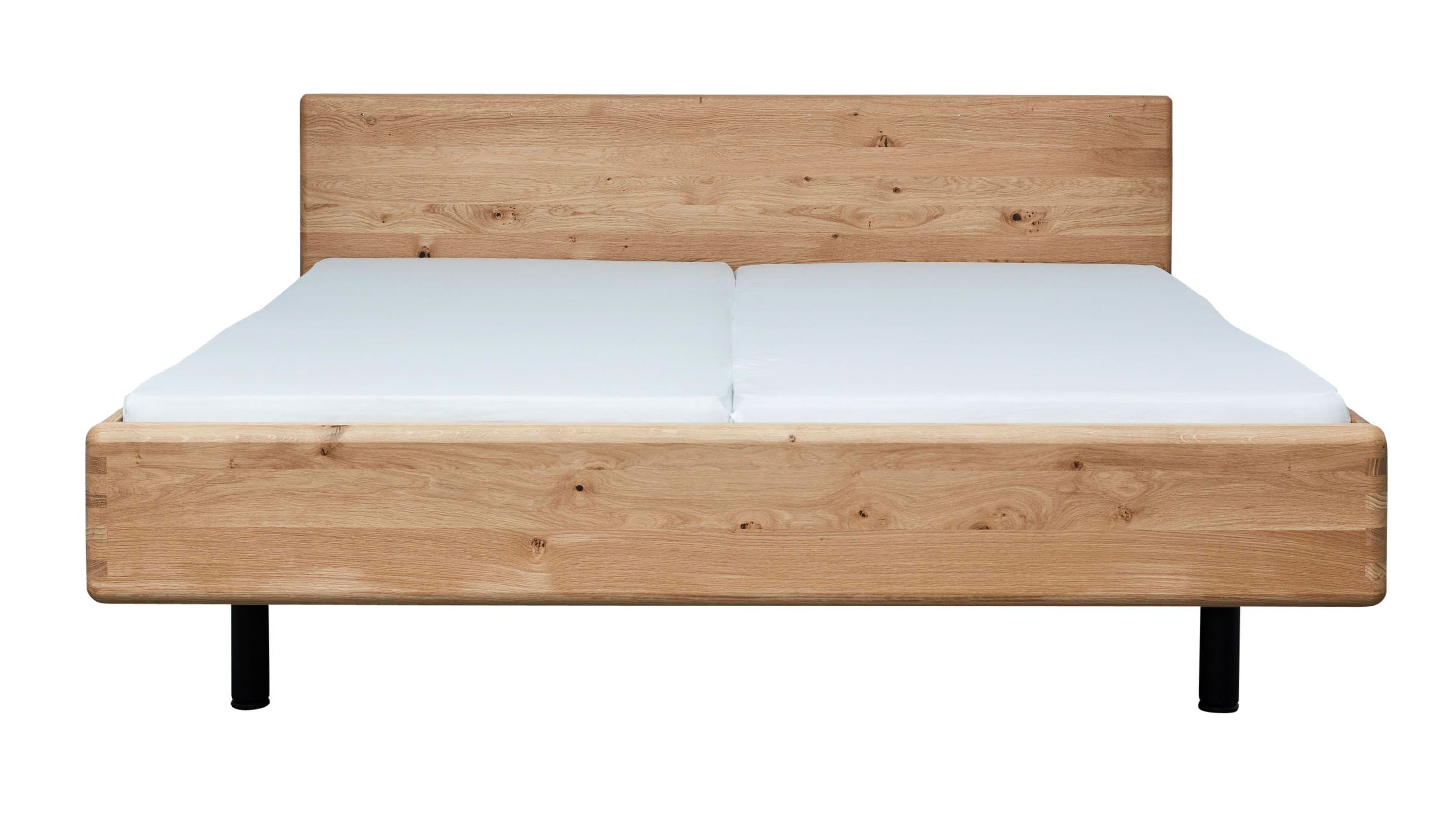 Bettgestell aus hellem Holz mit Kopfteil und Matratze Bettgestell aus hellem Holz mit rechteckigem Kopfteil und weißer Matratze