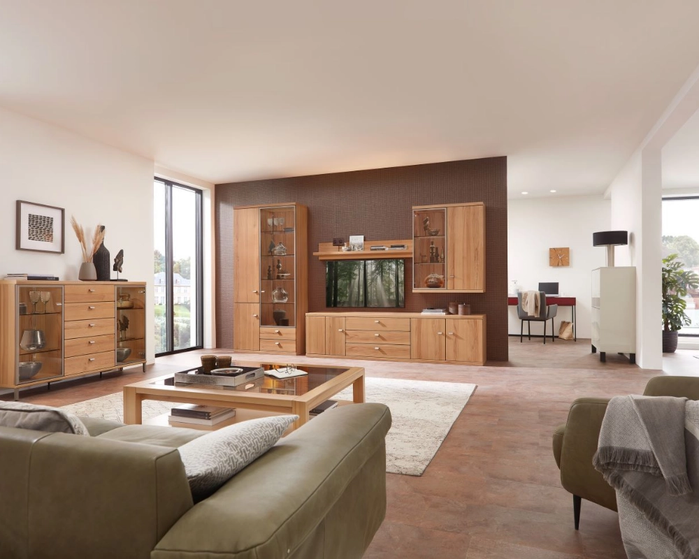 Modernes Wohnzimmer mit wohnlicher Holzwohnwand und gemütlicher Sitzgruppe. Großzügiges Wohnzimmer mit Wohnwand in Holzoptik, grünem Sofa und Couchtisch auf hellem Teppich.