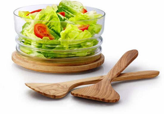 Glasglocke mit Holzunterteil als Salatschale genutzt  gefüllt mit frischem Salat  daneben Salatbesteck aus Holz