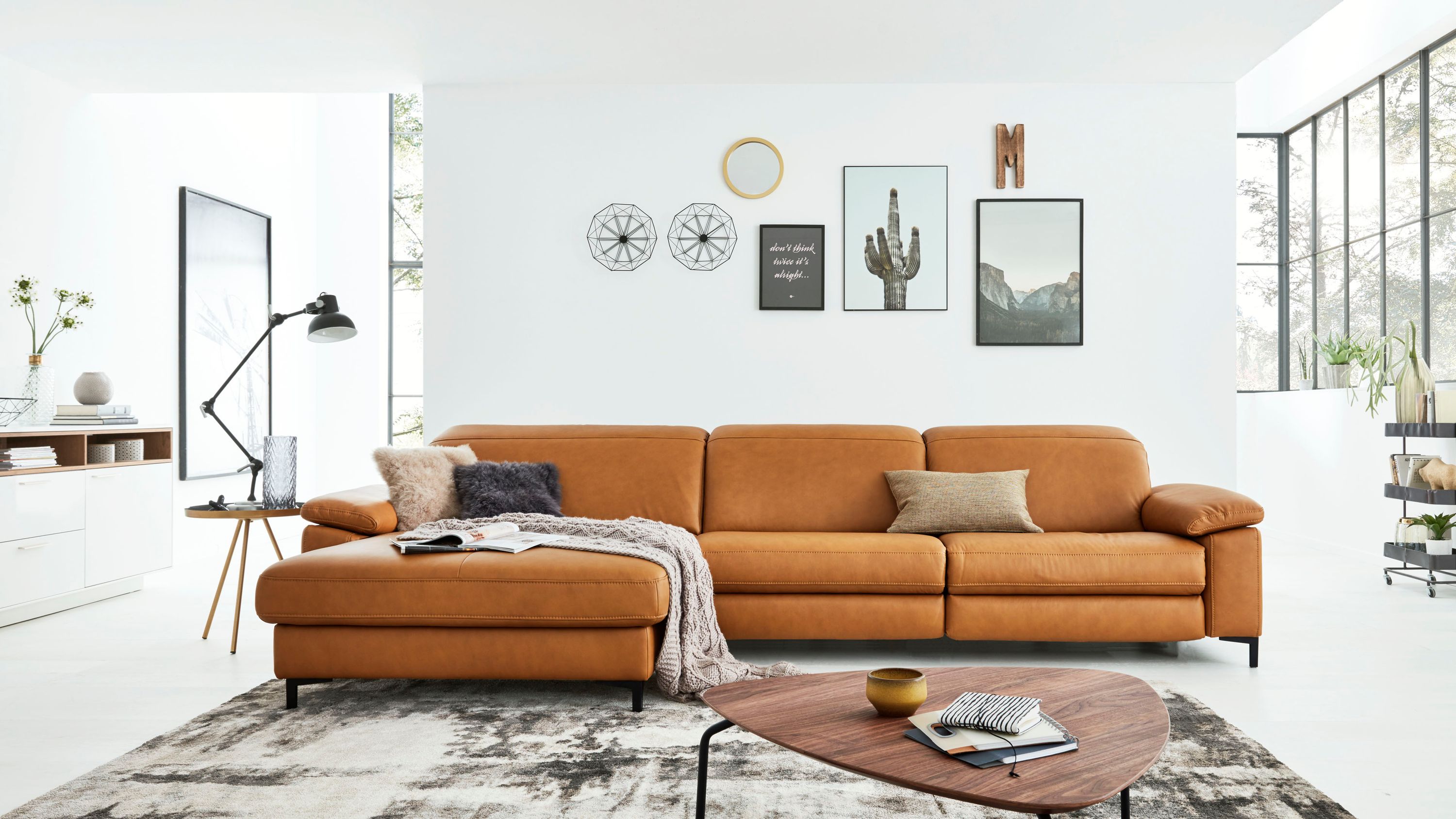 Ecksofa mit kurkumafarbenem Lederbezug und schwarzen Metallfüßen in modernem Wohnzimmer