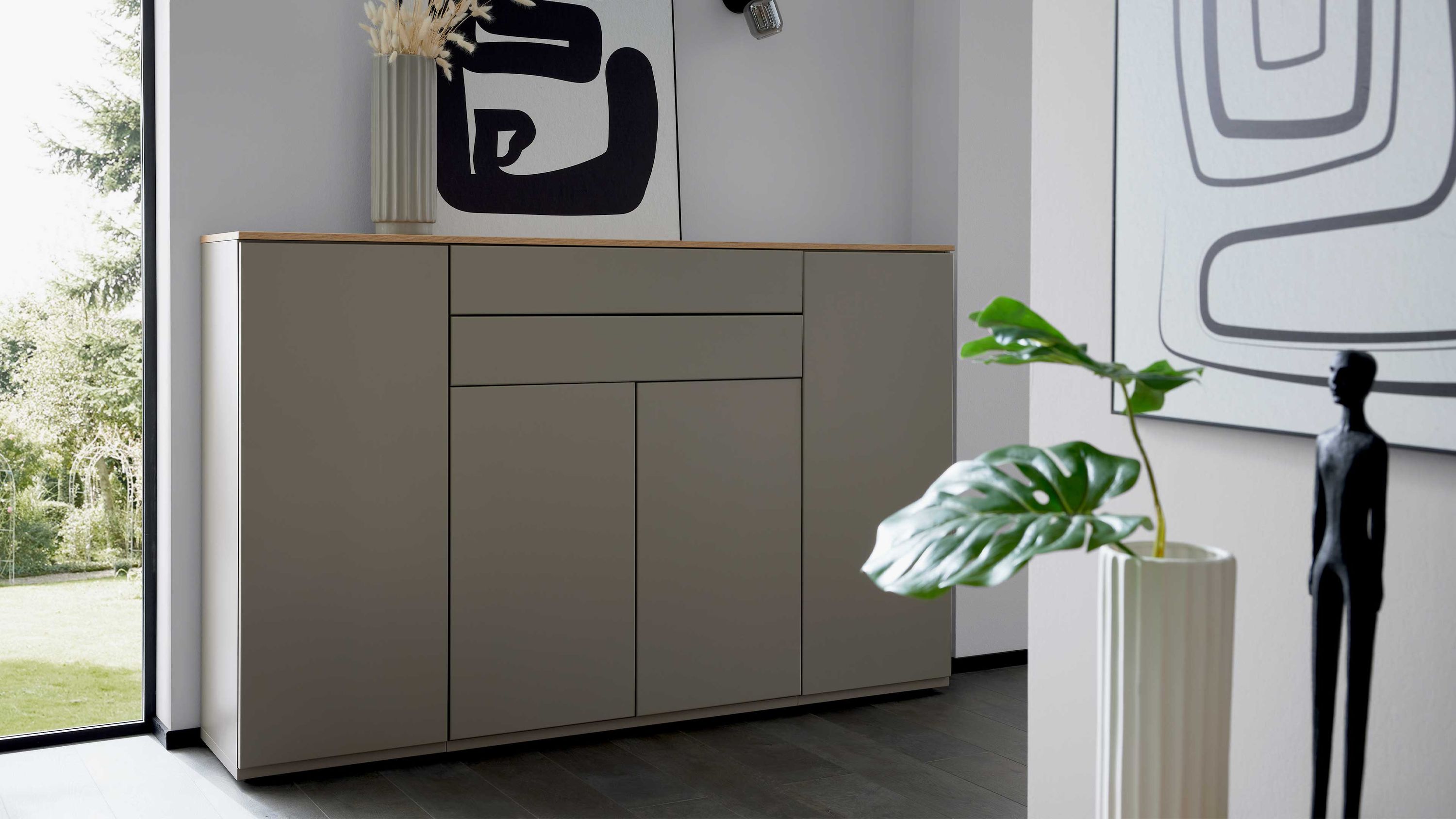 Graues Highboard mit vier Türen und zwei Schubladen Helles Highboard mit vier Türen und zwei Schubladen in grauer Farbe mit heller Abdeckplatte in Wohnraum