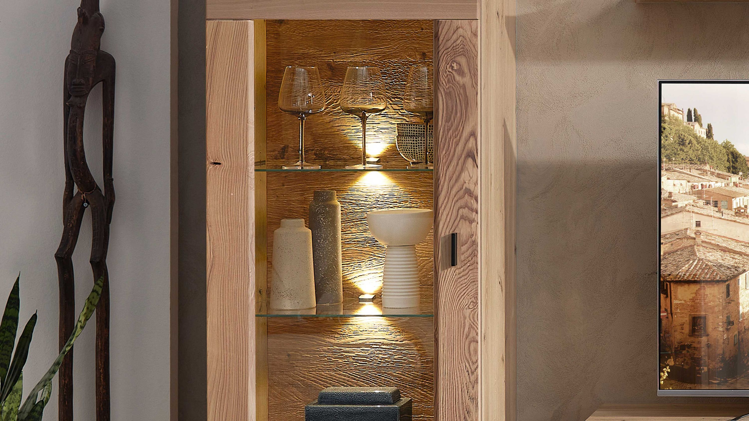Vitrine aus hellem Holz mit drei Glasböden und integrierter LED-Beleuchtung gefüllt mit Gläsern und Vasen