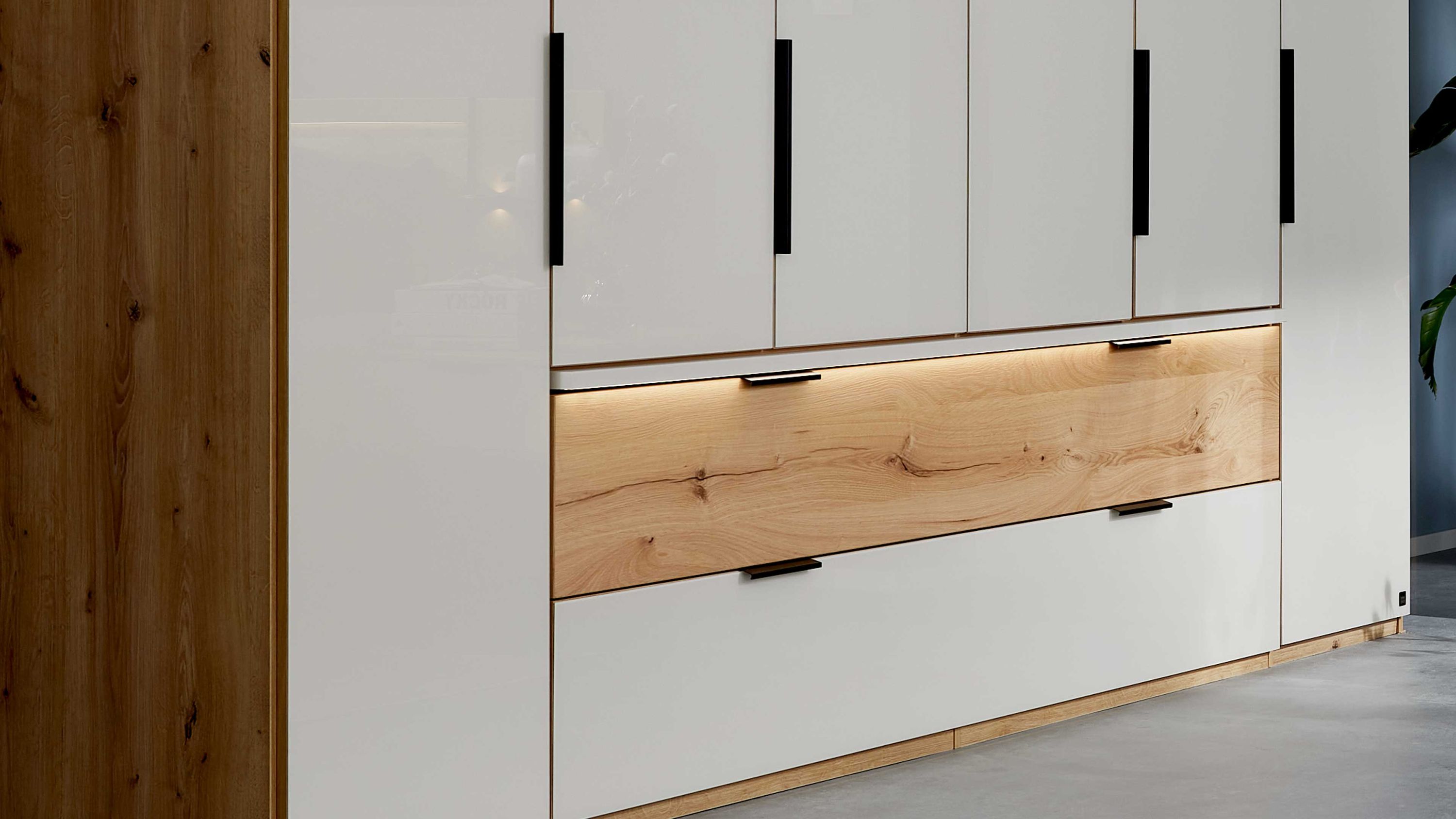 Schlafzimmerschrank mit weißen Fronten Holzblende und integrierter Beleuchtung unter der Holzblende