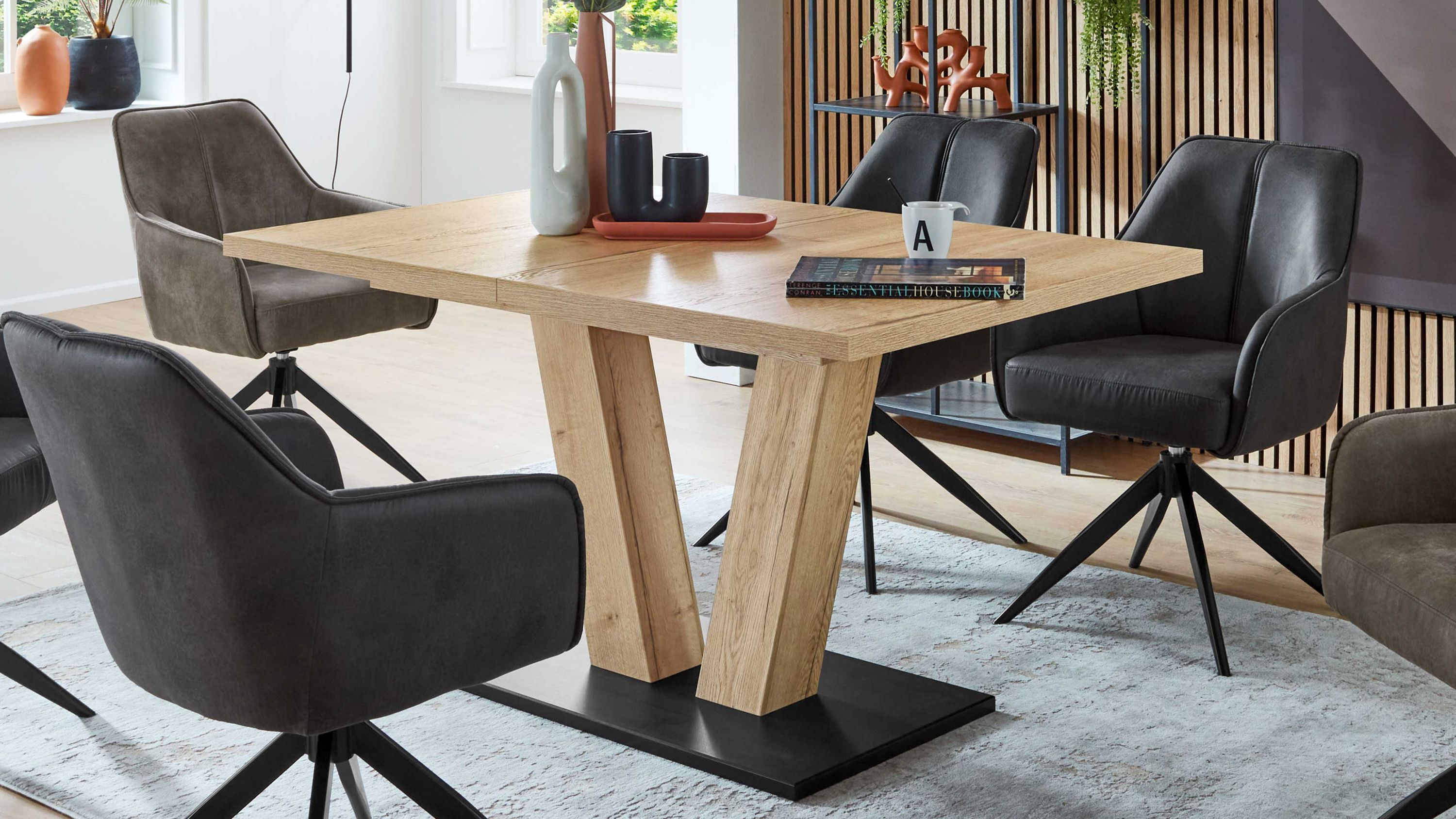 Ausziehtisch mit Holzplatte und schwarzer Basis Ausziehtisch mit rechteckiger Holzplatte und zwei schrägen Holzbeinen auf schwarzer Grundplatte