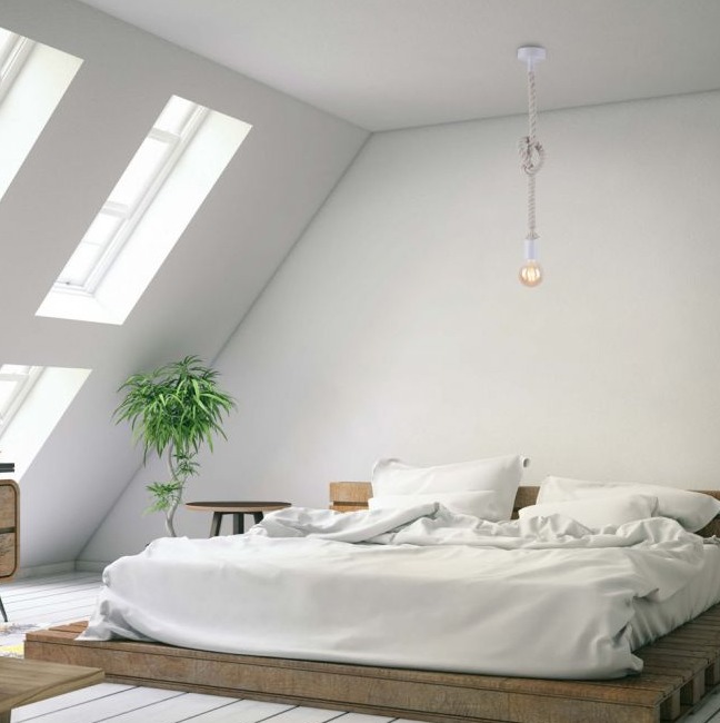 Weiße Pendelleuchte über Bett in Schlafzimmer mit Dachschräge großen Fenstern weißer Bettwäsche und Zimmerpflanze