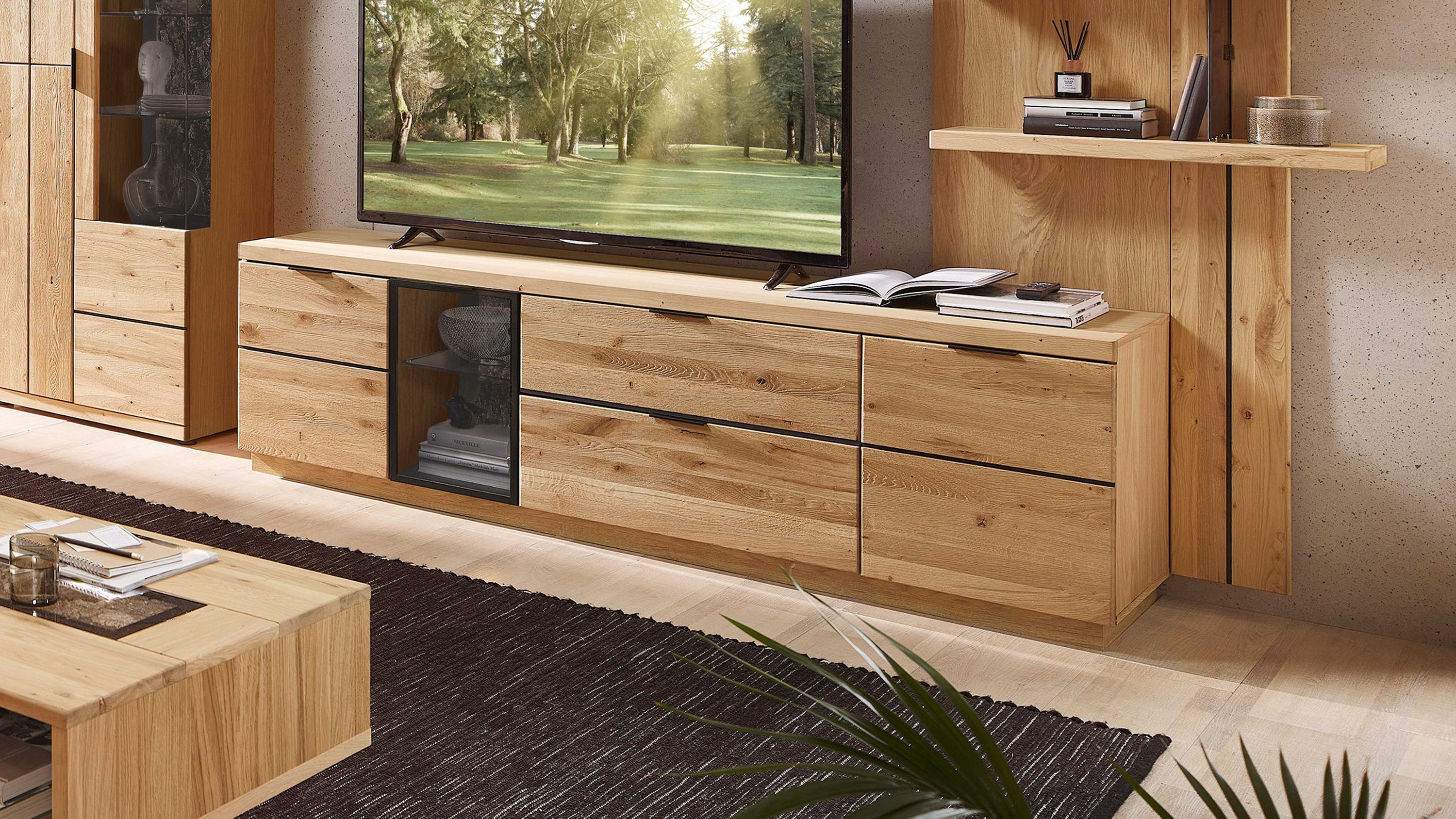 Lowboard in heller Holzoptik mit Türen und Schublade Lowboard mit vier Türen und einer Schublade in heller Holzoptik mit schwarzem Griff Fernseher darauf