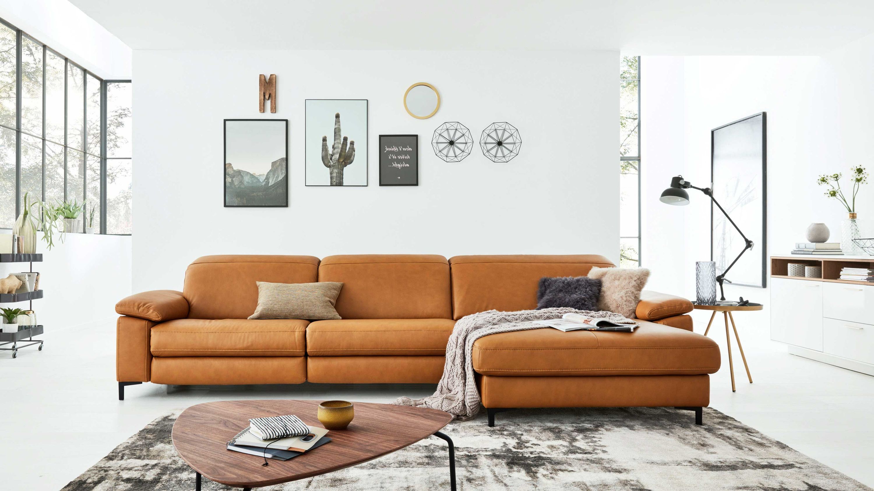 Ecksofa mit kurkumafarbenem Lederbezug und schwarzen Metallfüßen in modernem Wohnzimmer