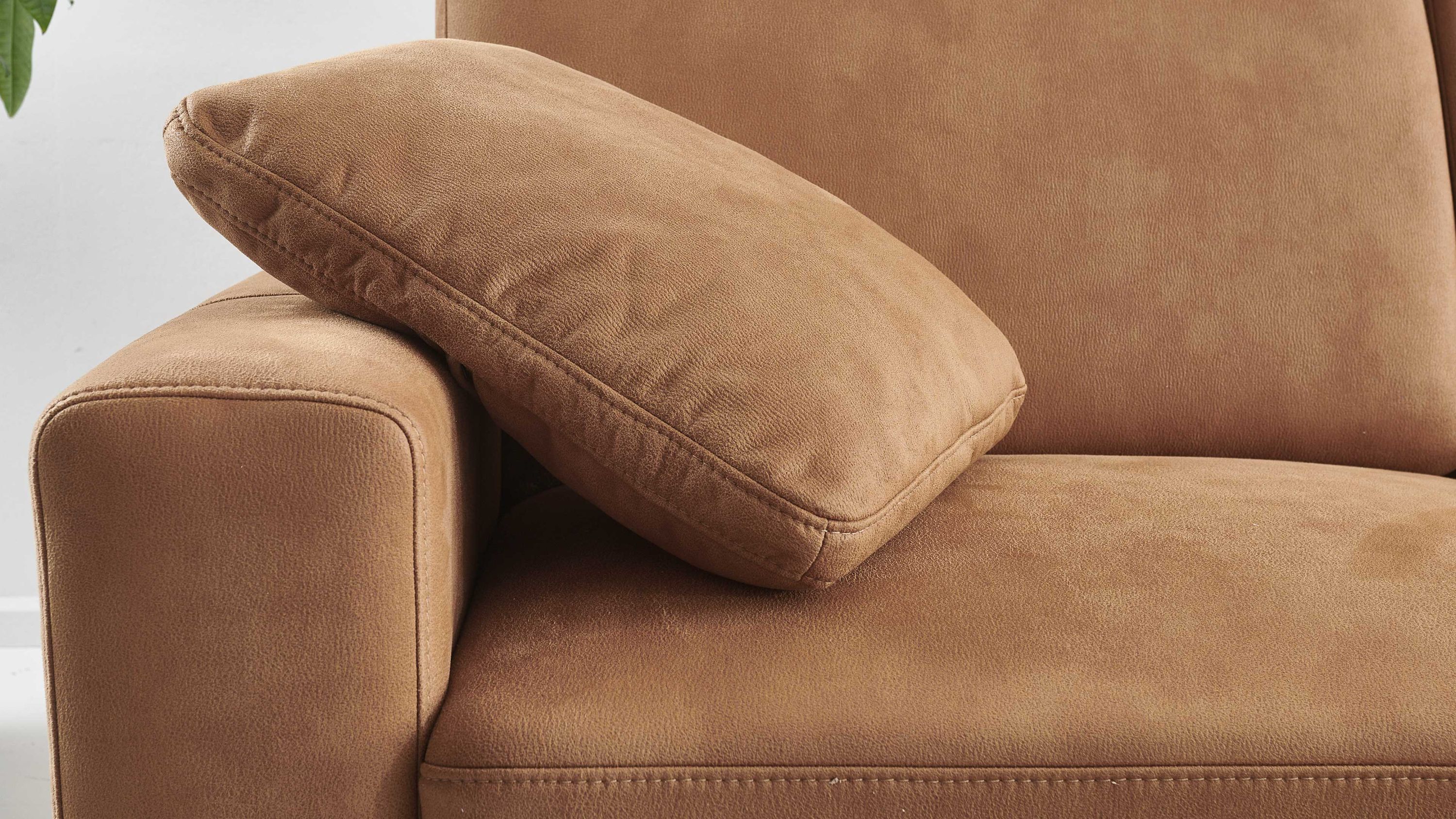 Zimtfarbenes rechteckiges Kissen auf der Armlehne eines Sofas in gleicher Farbe