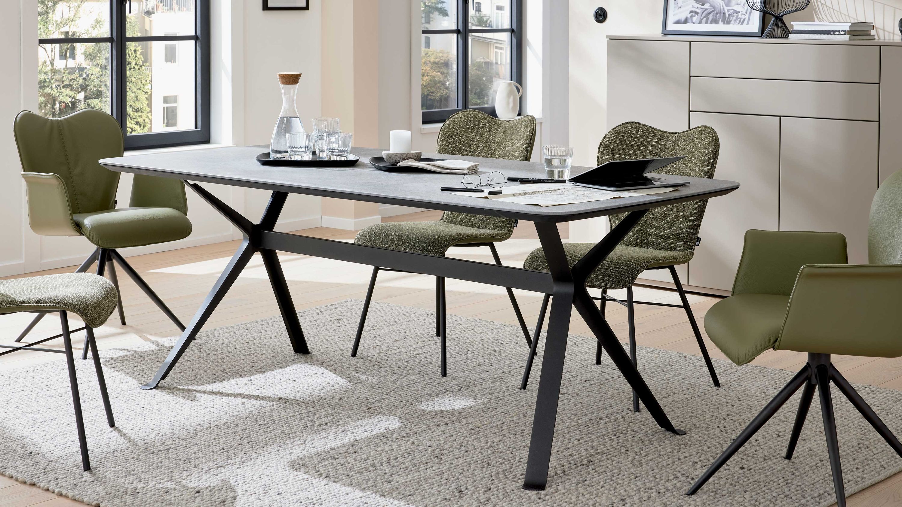 Rechteckiger Esstisch mit grauer Tischplatte und schwarzem Metallgestell in modernem Esszimmer