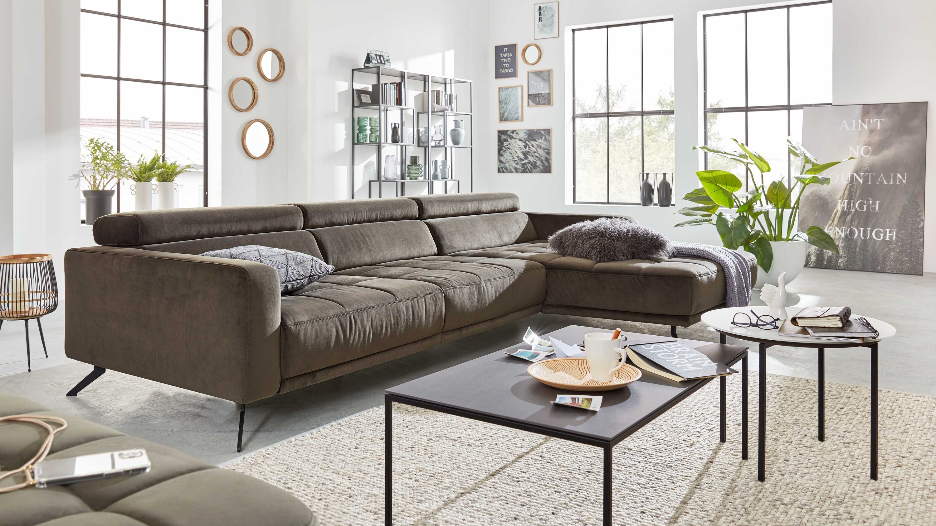 Ecksofa mit olivgrünem Stoffbezug und verstellbaren Kopfstützen in modernem Wohnzimmer