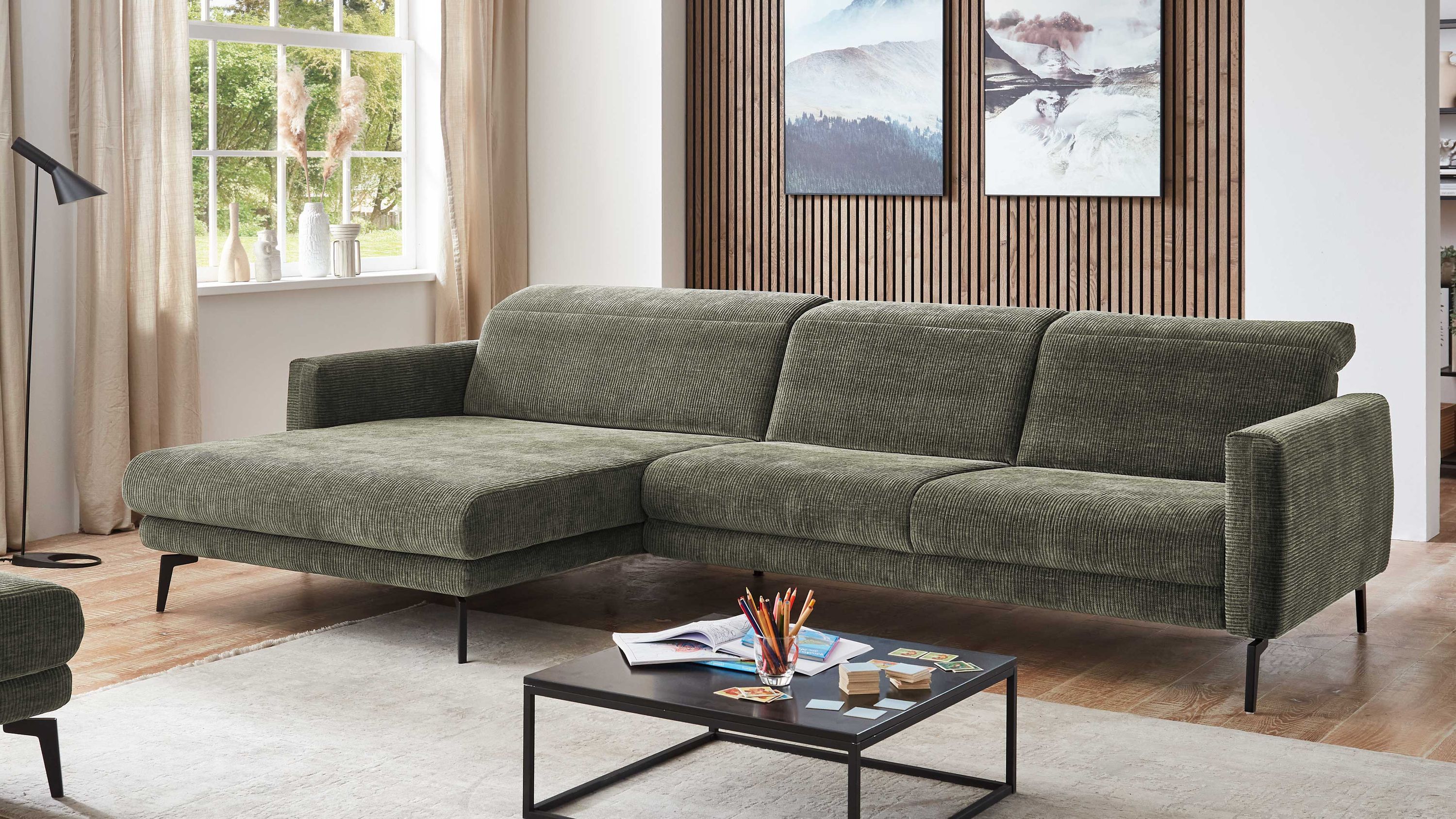 Ecksofa mit olivgrünem Flachgewebe und schwarzen Metallfüßen in modernem Wohnzimmer