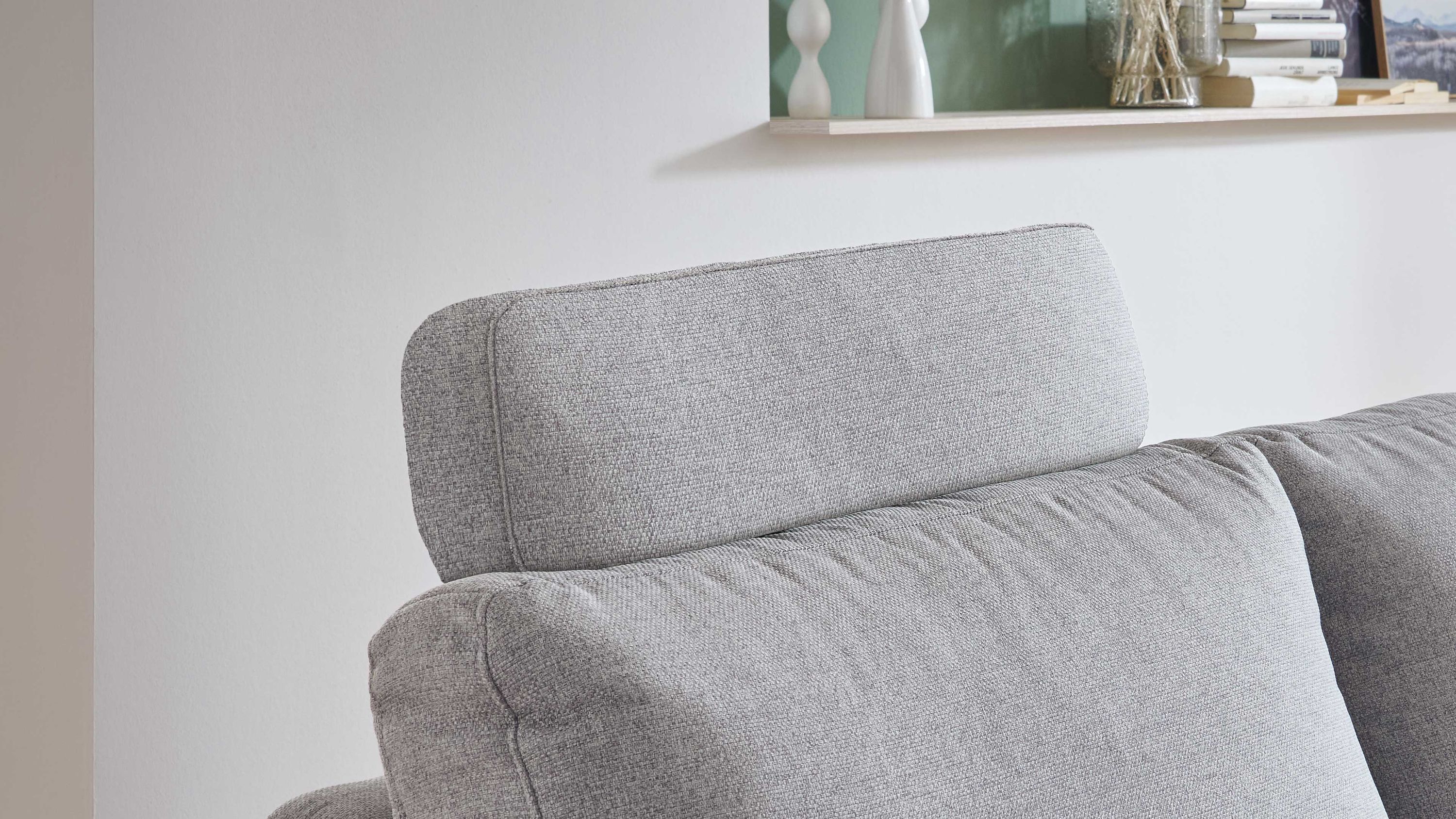 Sofa mit hellgrauer Kopfstütze aus Flachgewebe Hellgraue Kopfstütze aus Flachgewebe auf hellgrauem Sofa mit weicher Polsterung