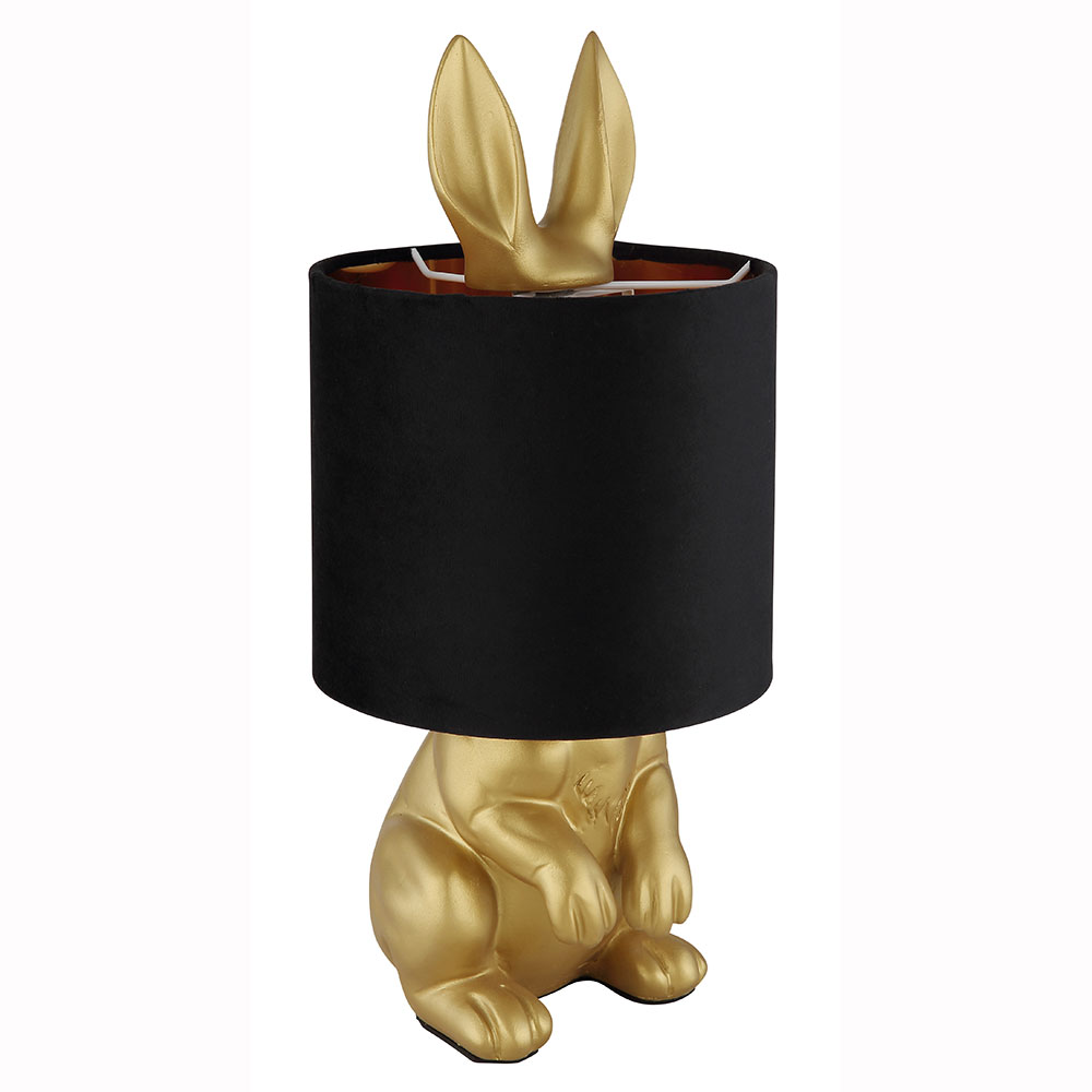 Goldene Hasenlampe mit schwarzem Schirm und herausragenden Ohren Goldfarbene Hasen-Tischleuchte mit schwarzem Lampenschirm, aus dem die langen Hasenohren oben herausragen, freigestellt
