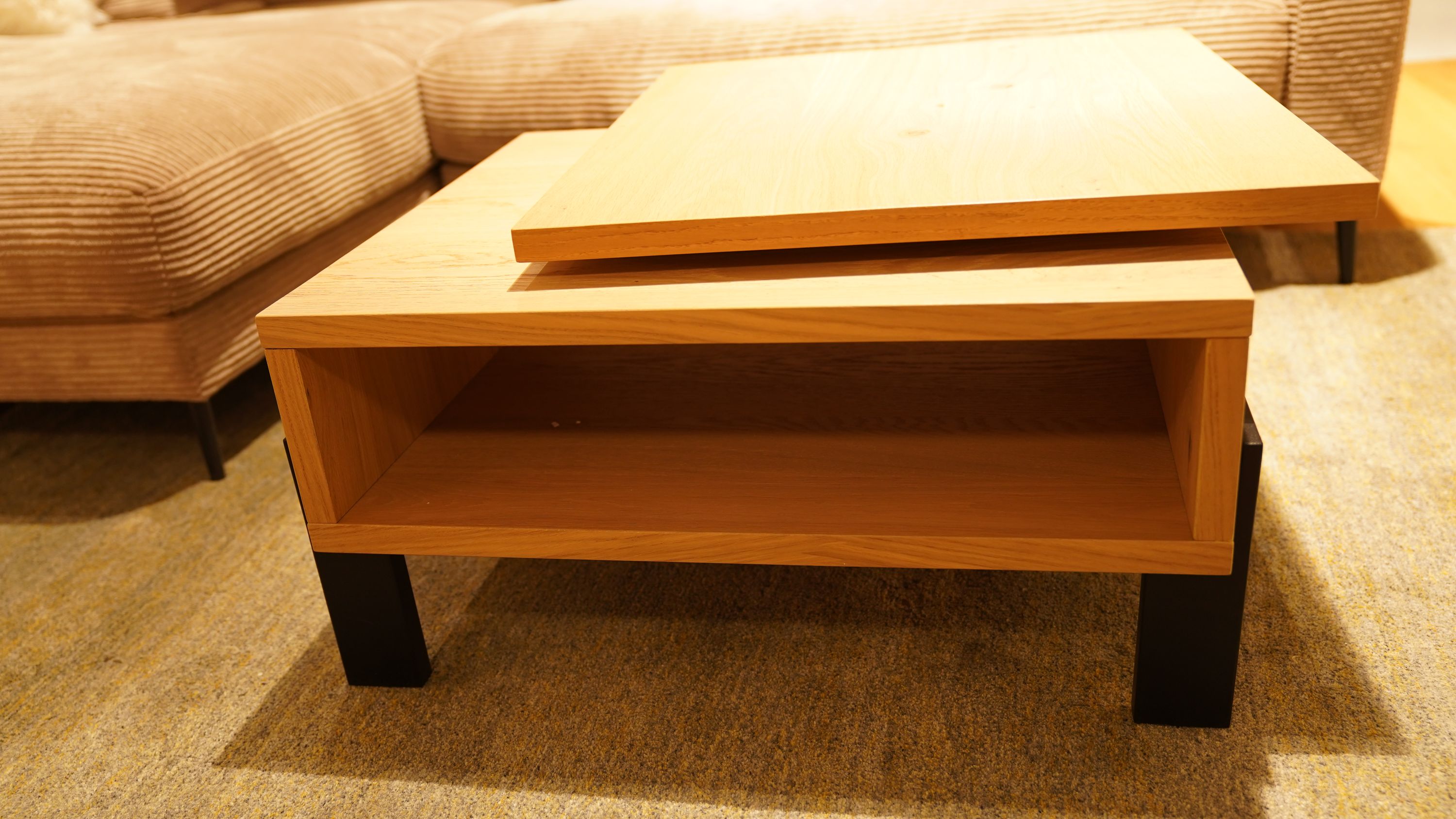 Moderner Couchtisch aus Holz mit schwarzem Gestell und offenem Fach