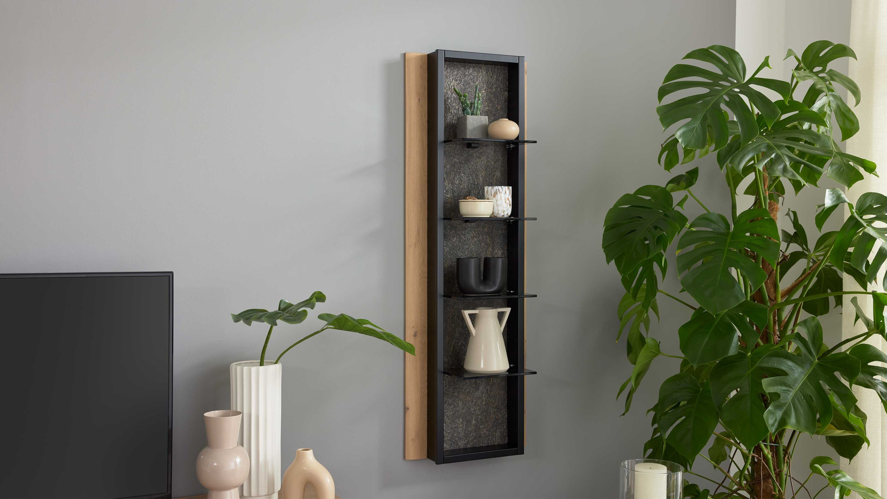 Schmales Wandregal mit Glasböden und Steinoptik Rückwand Schmales Wandregal mit schwarzem Rahmen und dunkler Steinoptik Rückwand vier Glasböden an grauer Wand mit Dekoration